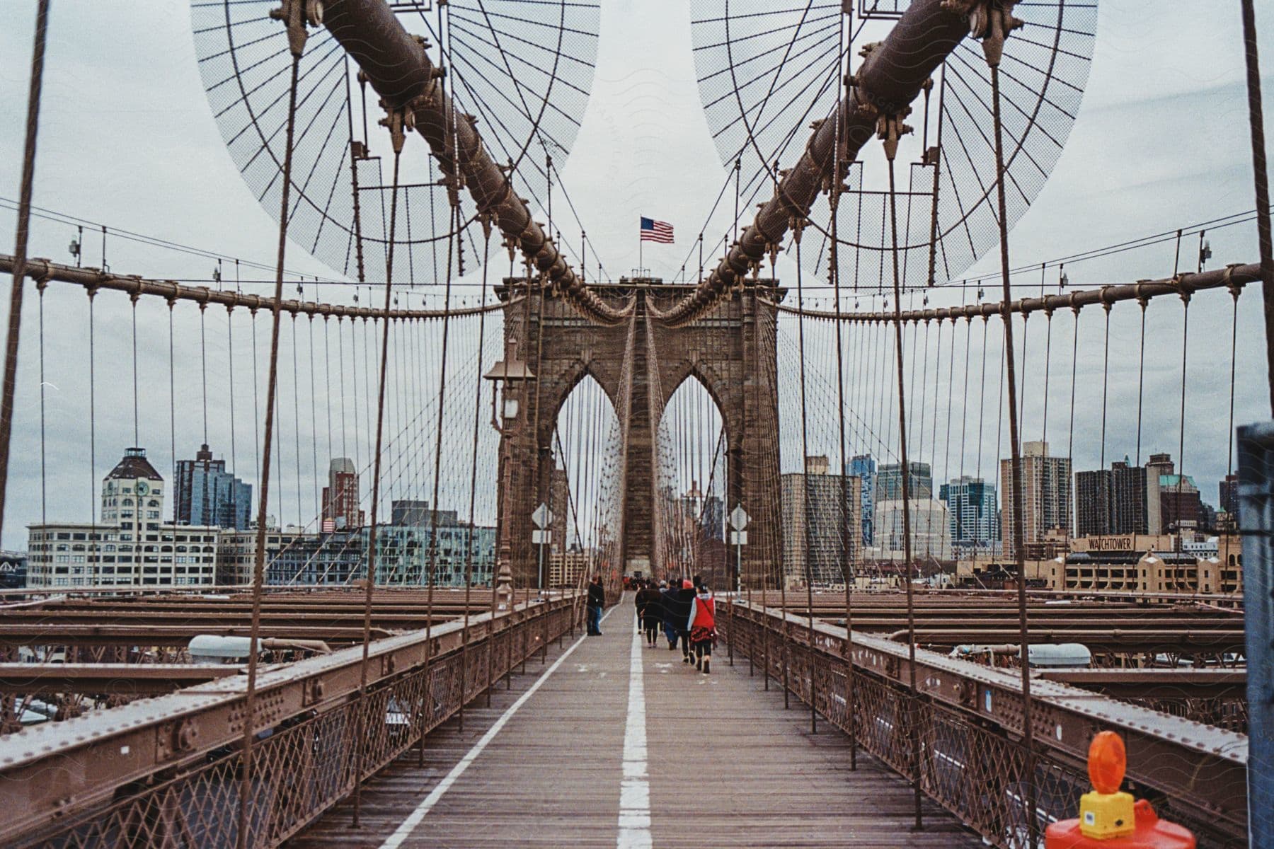 A small group of people standing near a downtown bridge and buildings