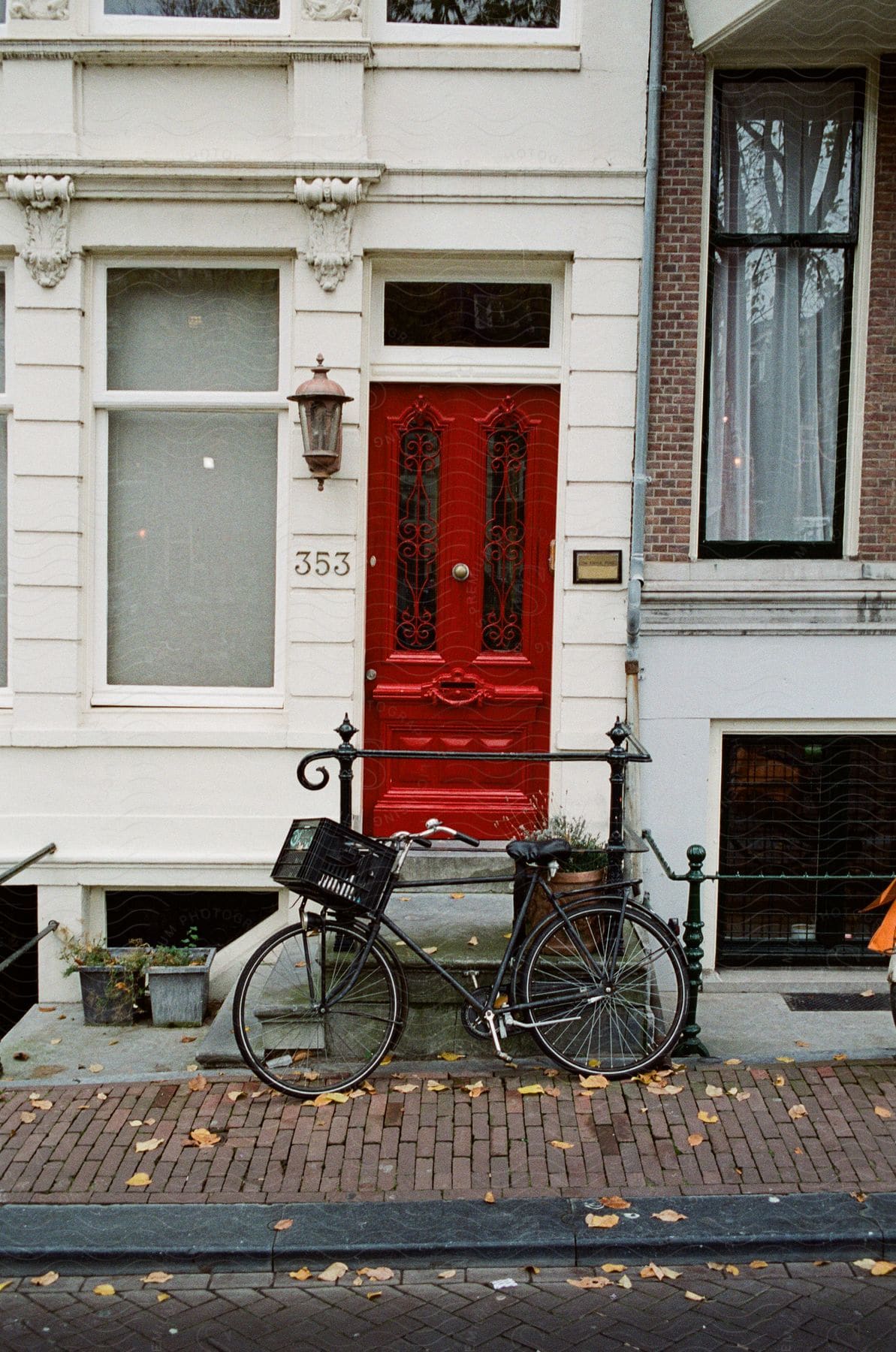 A parked bicycle is seen in front of a red front door