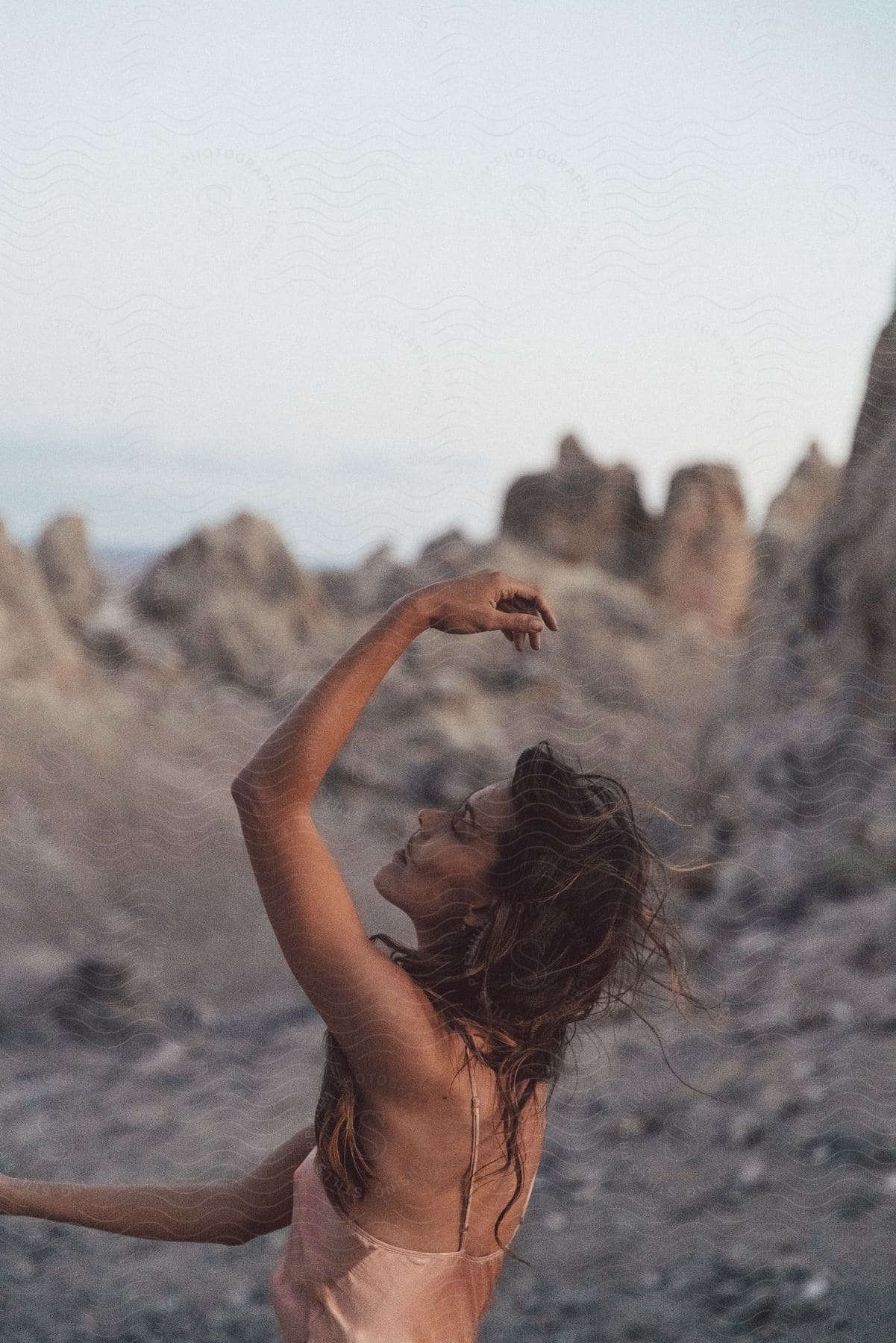 Stock photo of a woman poses near rocks on a rocky surface