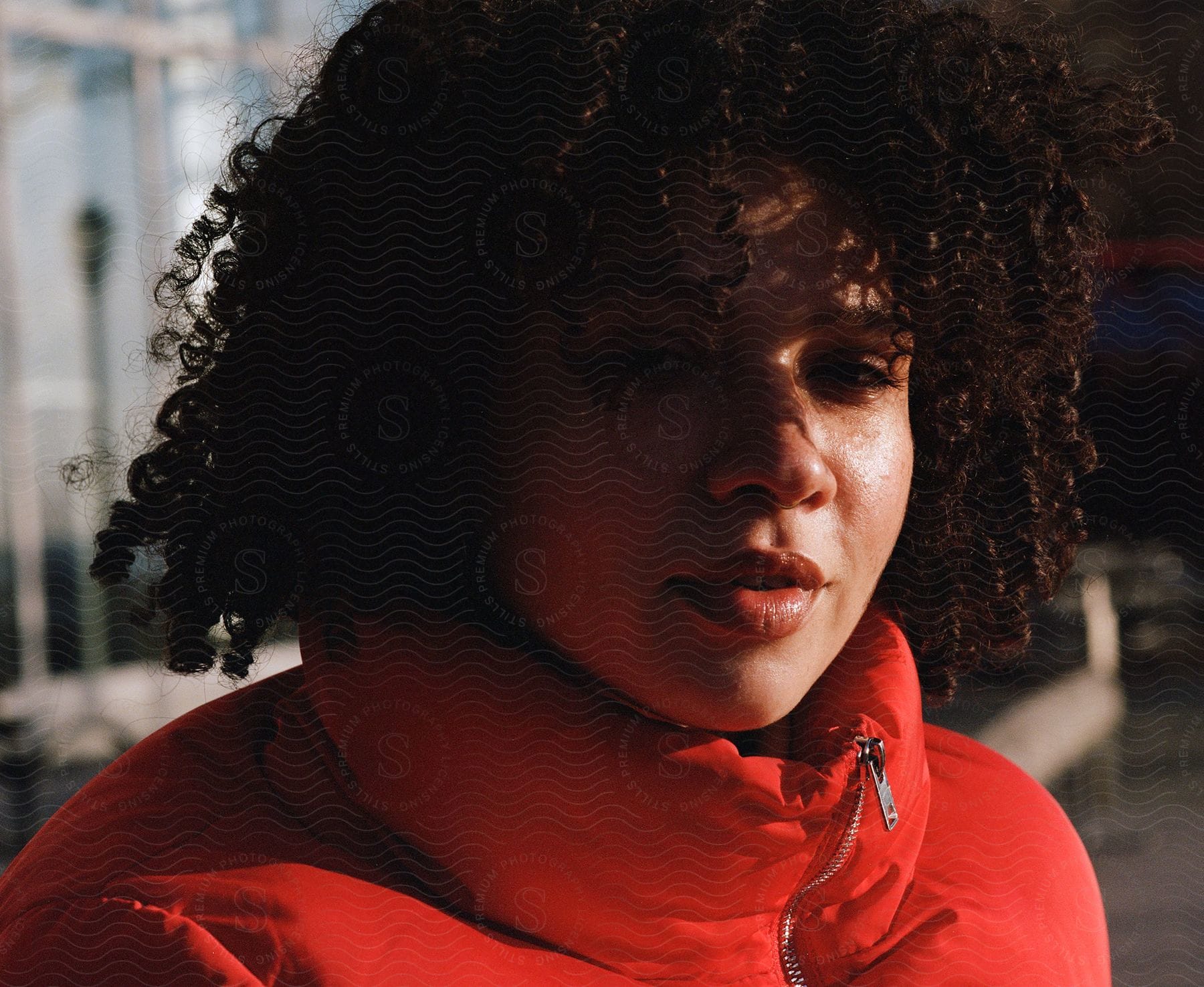 A woman wearing an orange jacket poses for a portrait shown from head to shoulders