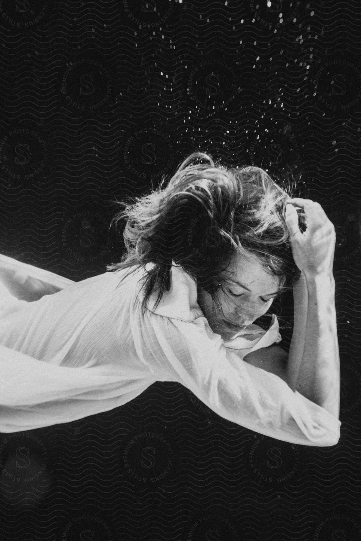 A sinking woman creates rising bubbles underwater