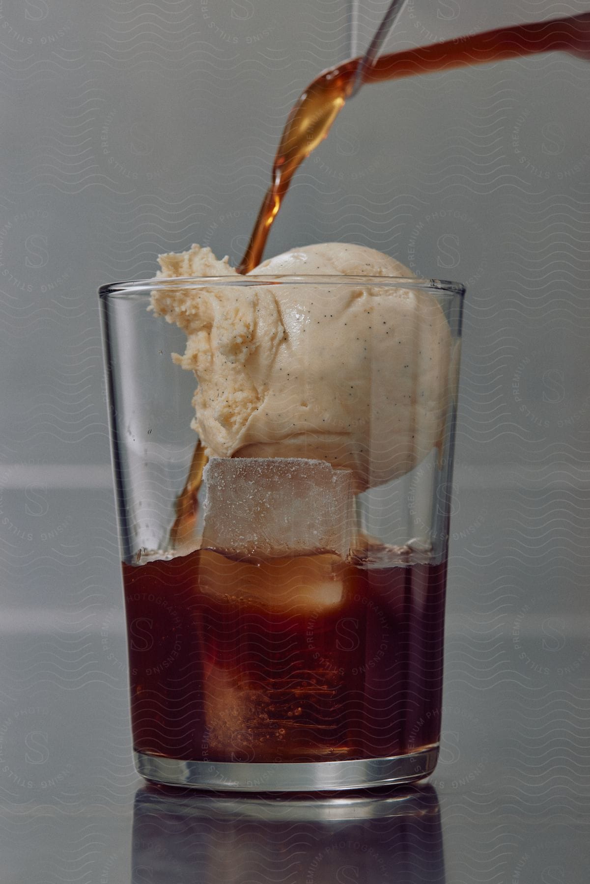 Coke poured over ice cream and ice in a drink preparation