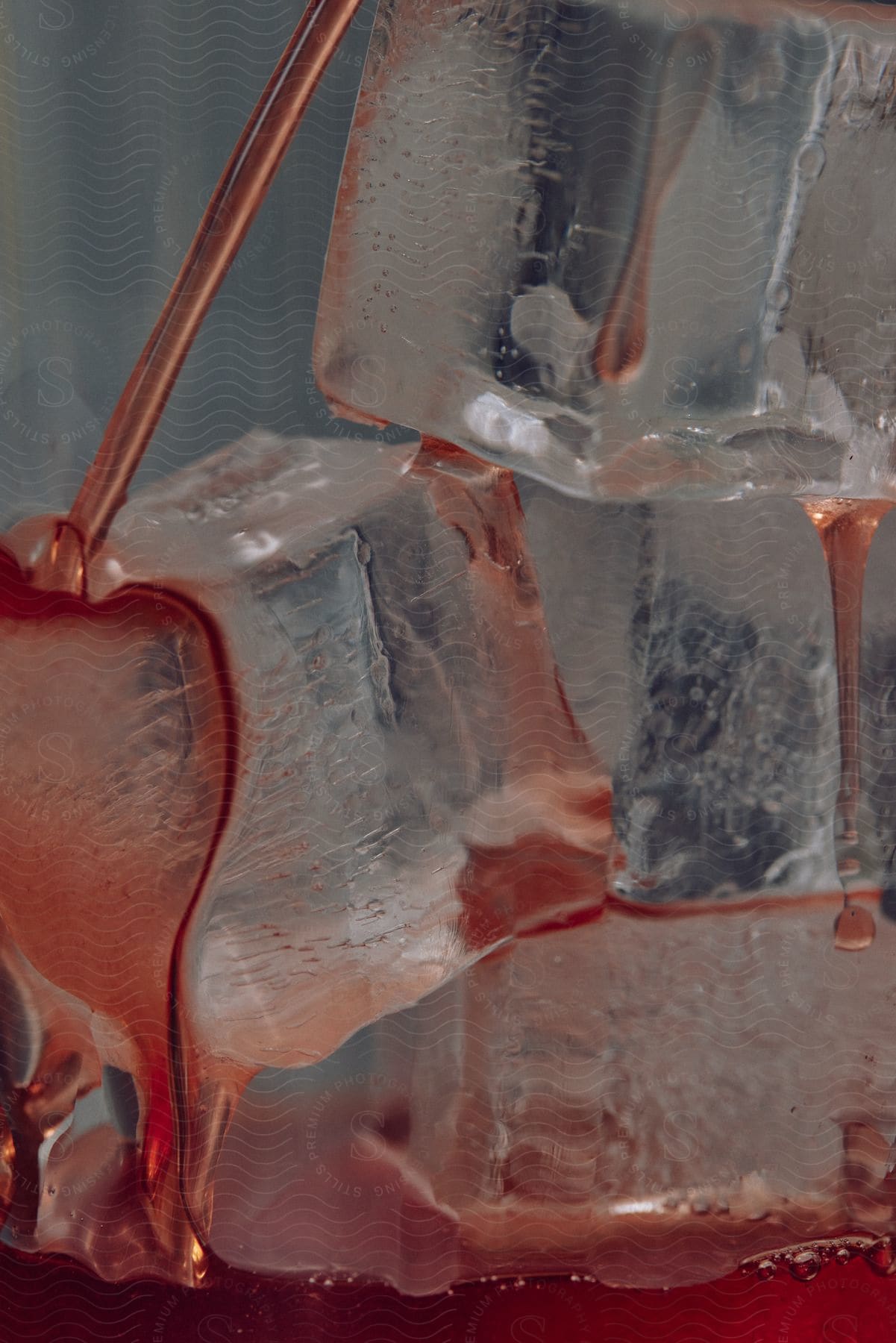 Closeup of syrup pouring on a glass filled with ice cubes