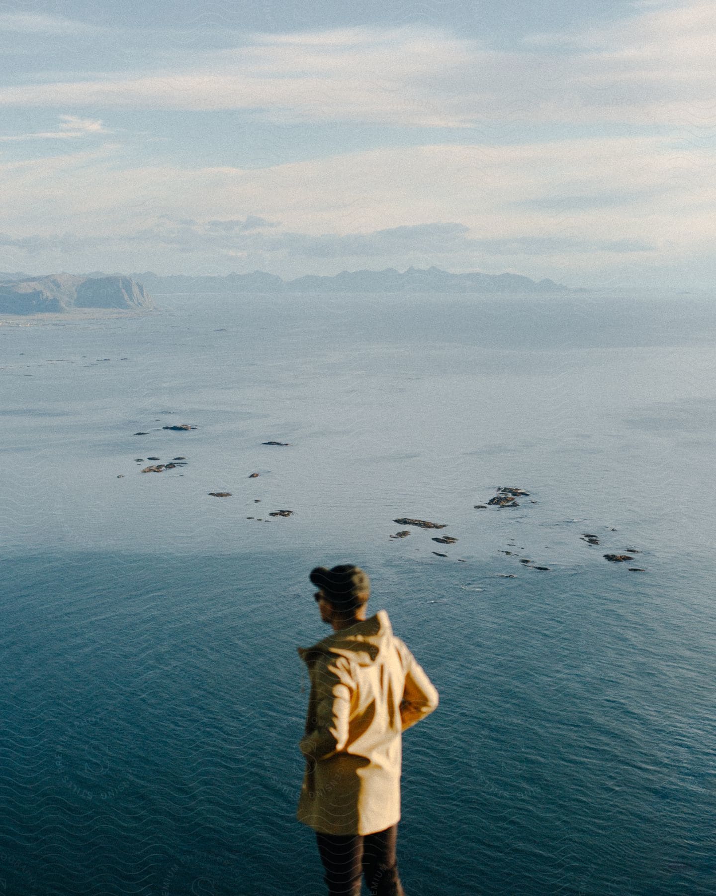 A person standing by a lake with a cloudy sky