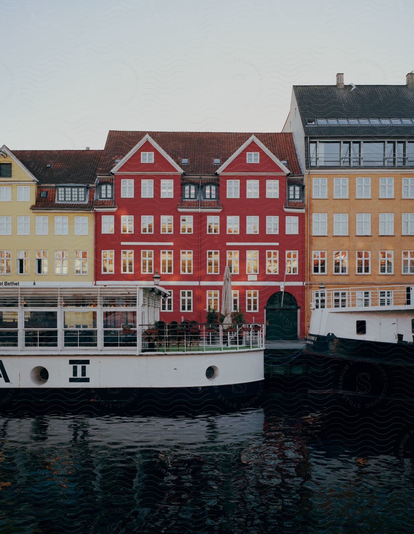 A boat with windows on a canal in the city