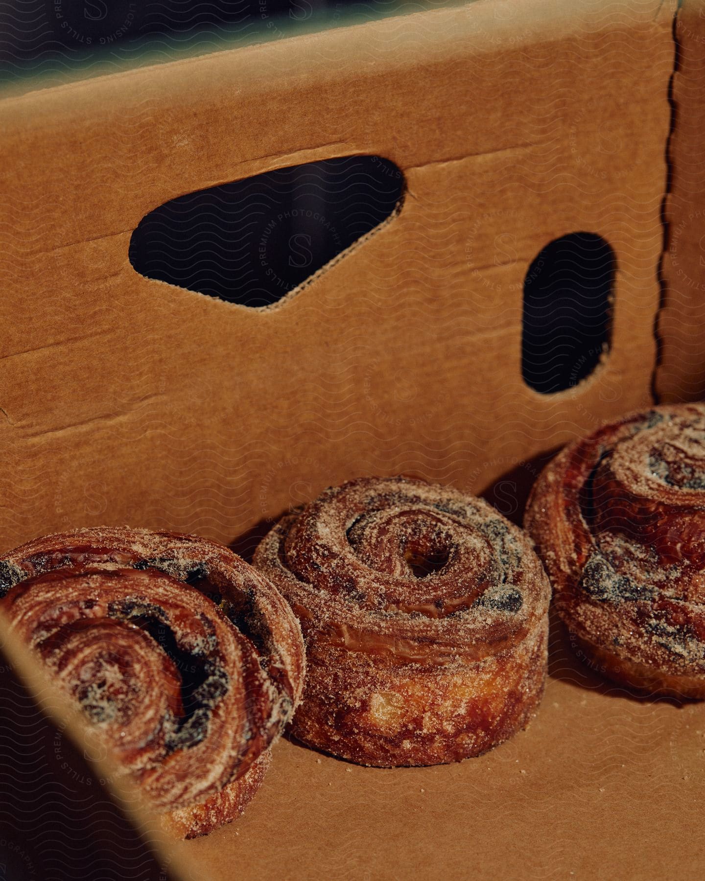 Sugar covered cinnamon rolls in a cardboard box