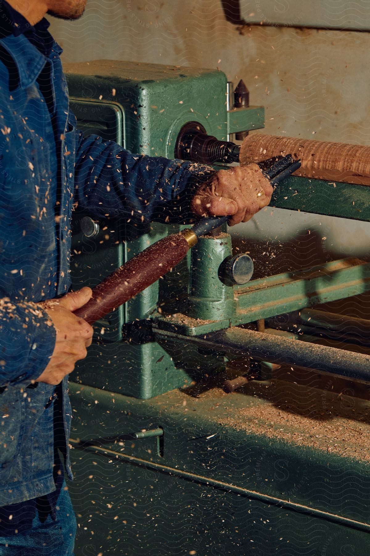 Stock photo of man operating a wood machine wearing denim in an industrial setting