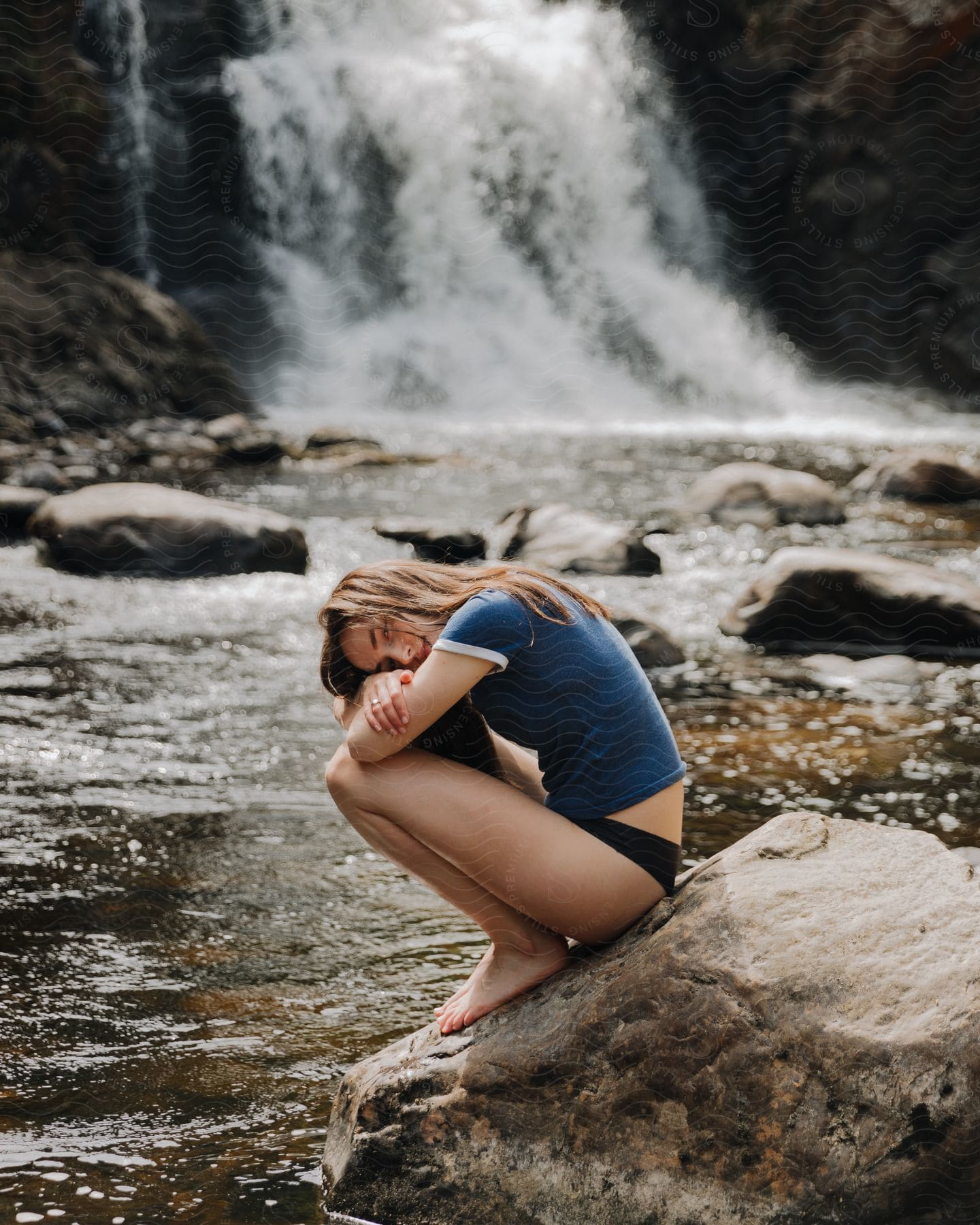 A woman sitting on a rock in the wilderness