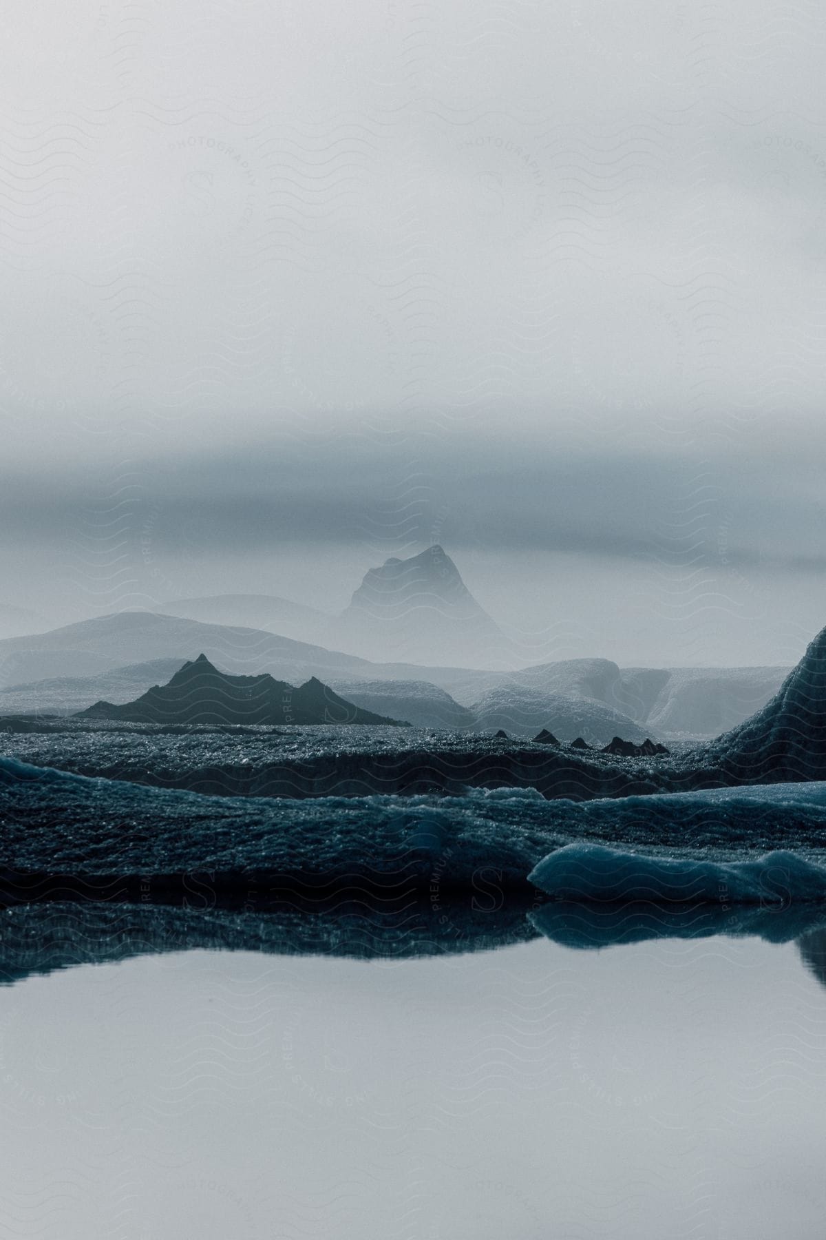 A large land with water and ice under a cloudy sky