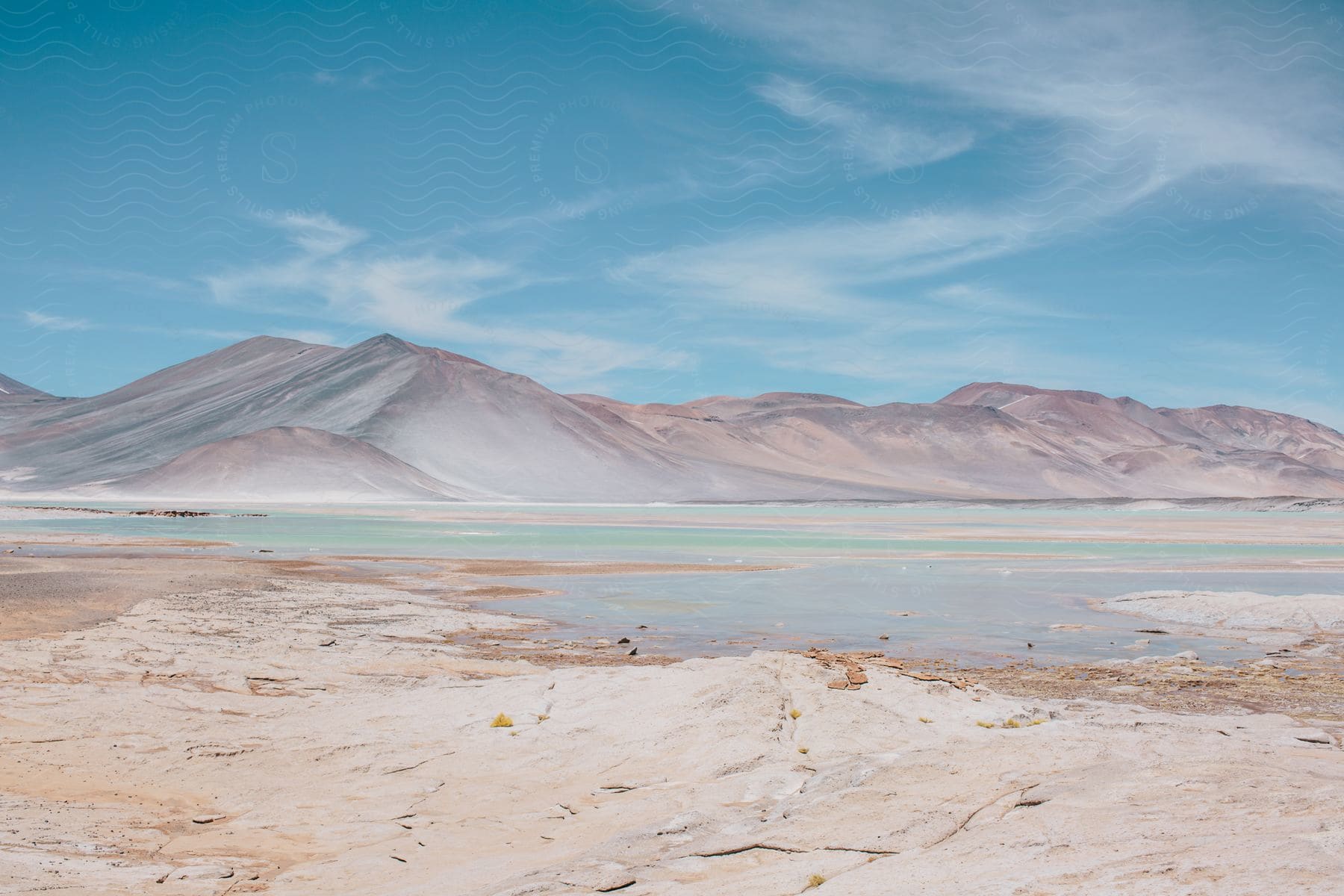 A serene landscape featuring a lake mountains and a clear sky