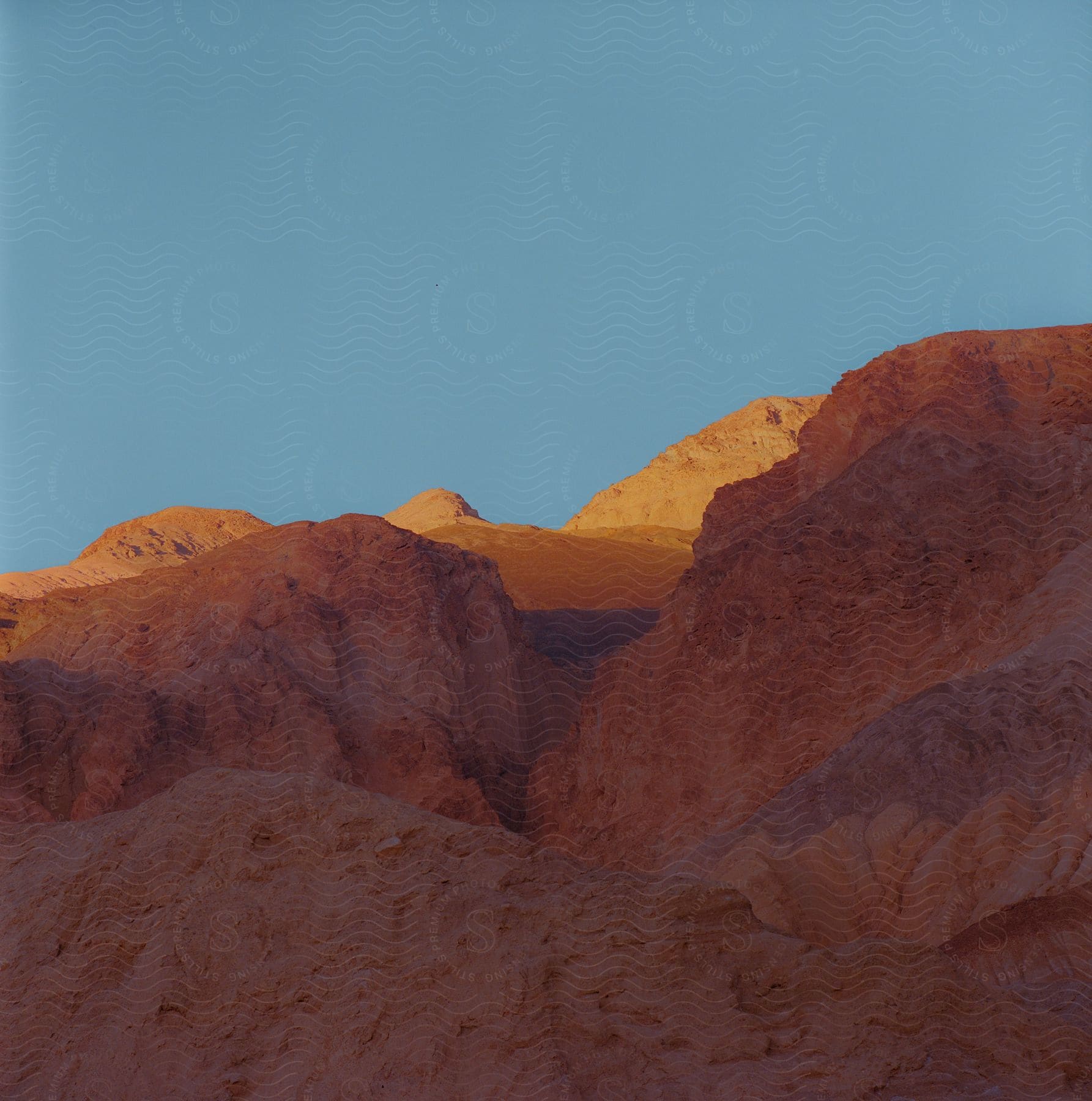 A rocky canyon with light shining through on the peaks