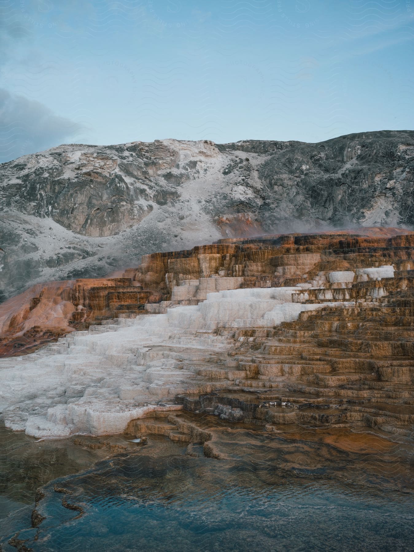 A serene natural landscape with water sky and rocky terrain