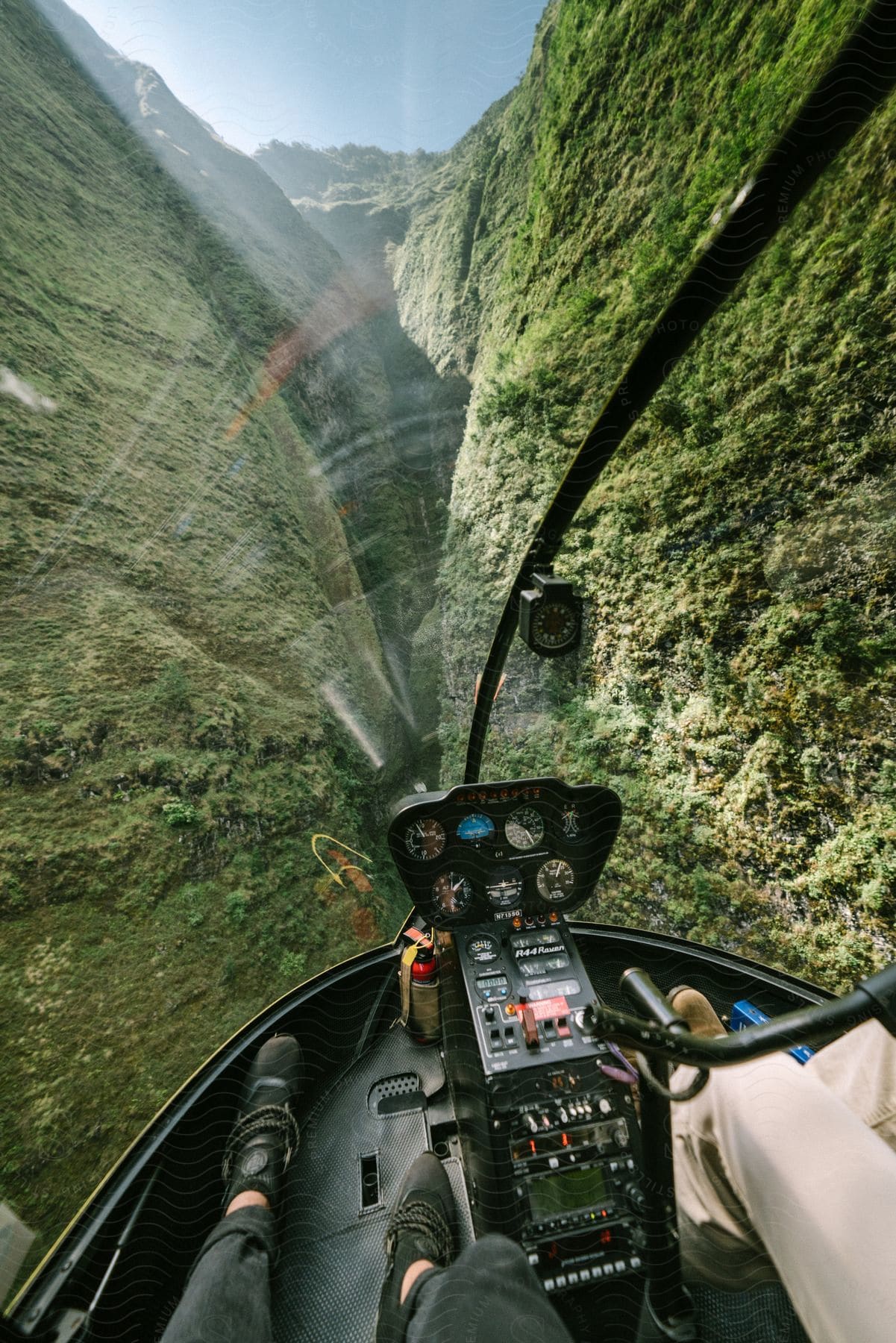Two men enjoy a breathtaking sight of mountains and green valleys from a helicopter cockpit