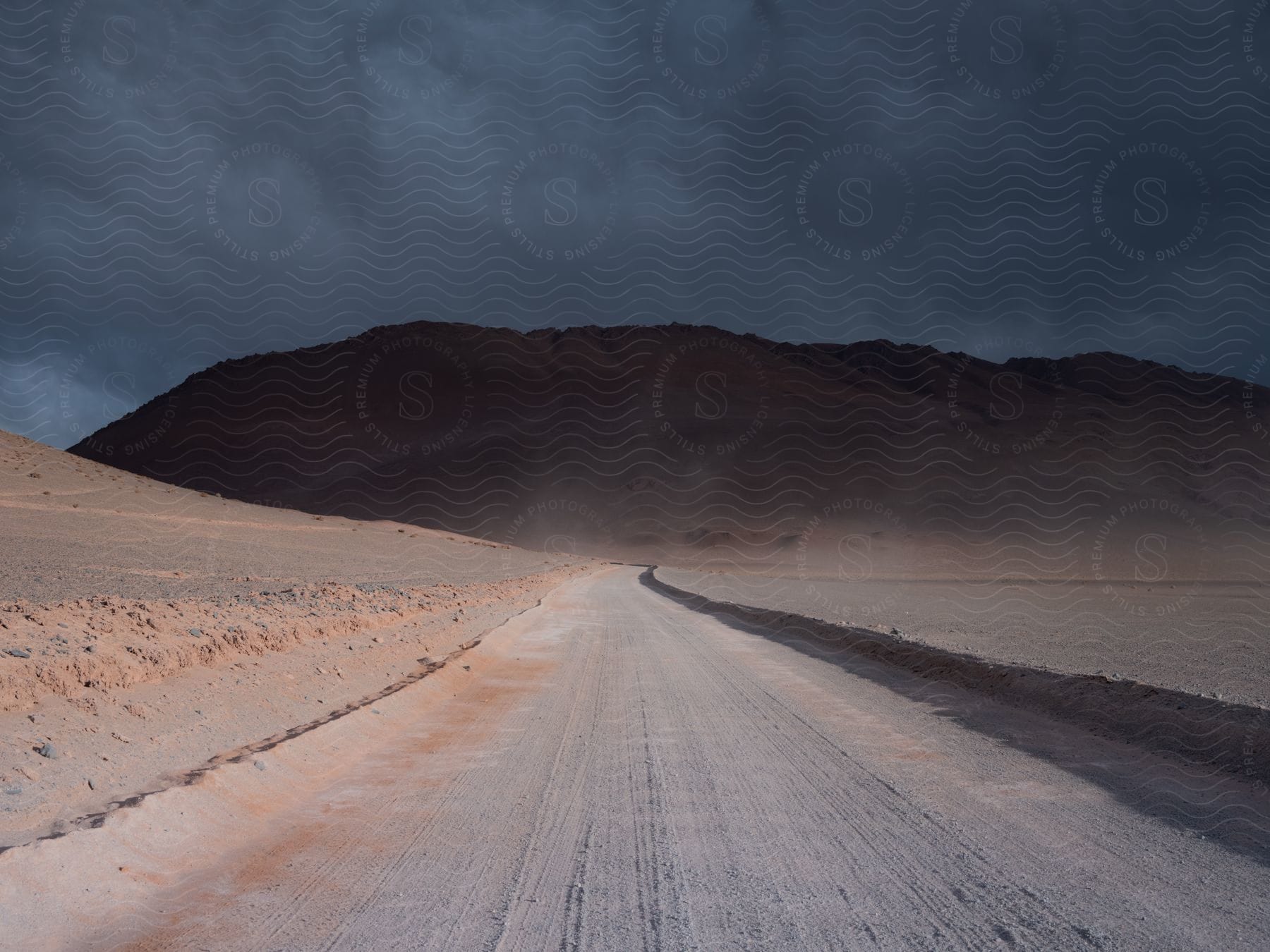 A road winding through mountains with clouds in the sky