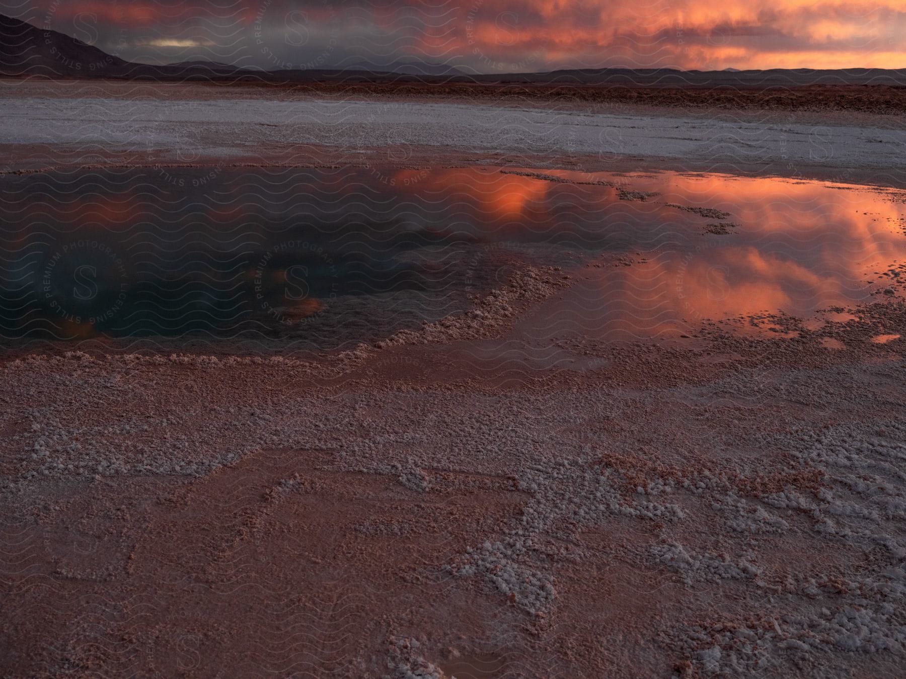 A lake in a plain with mountains on the horizon