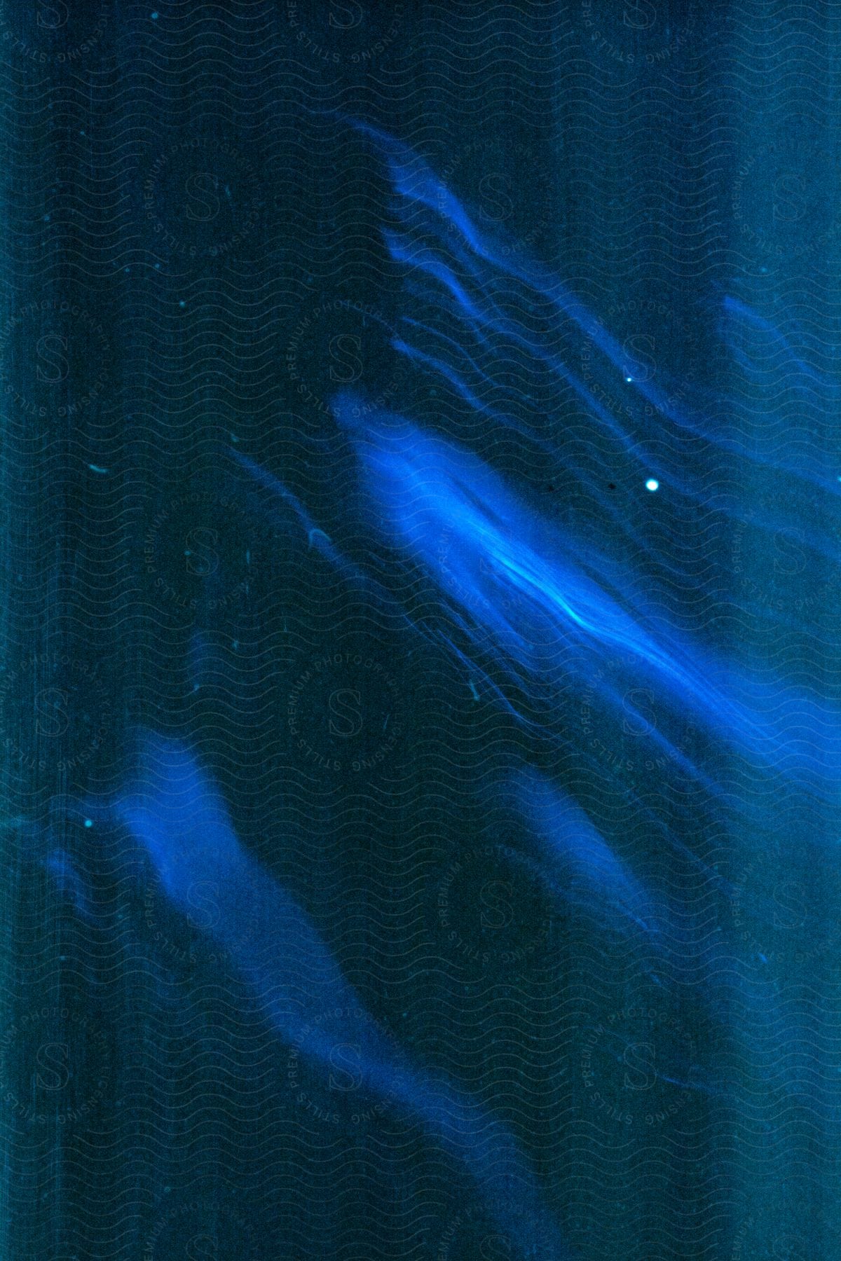 Abstract image of blurry lights and out of focus shape of a human with a blue tint