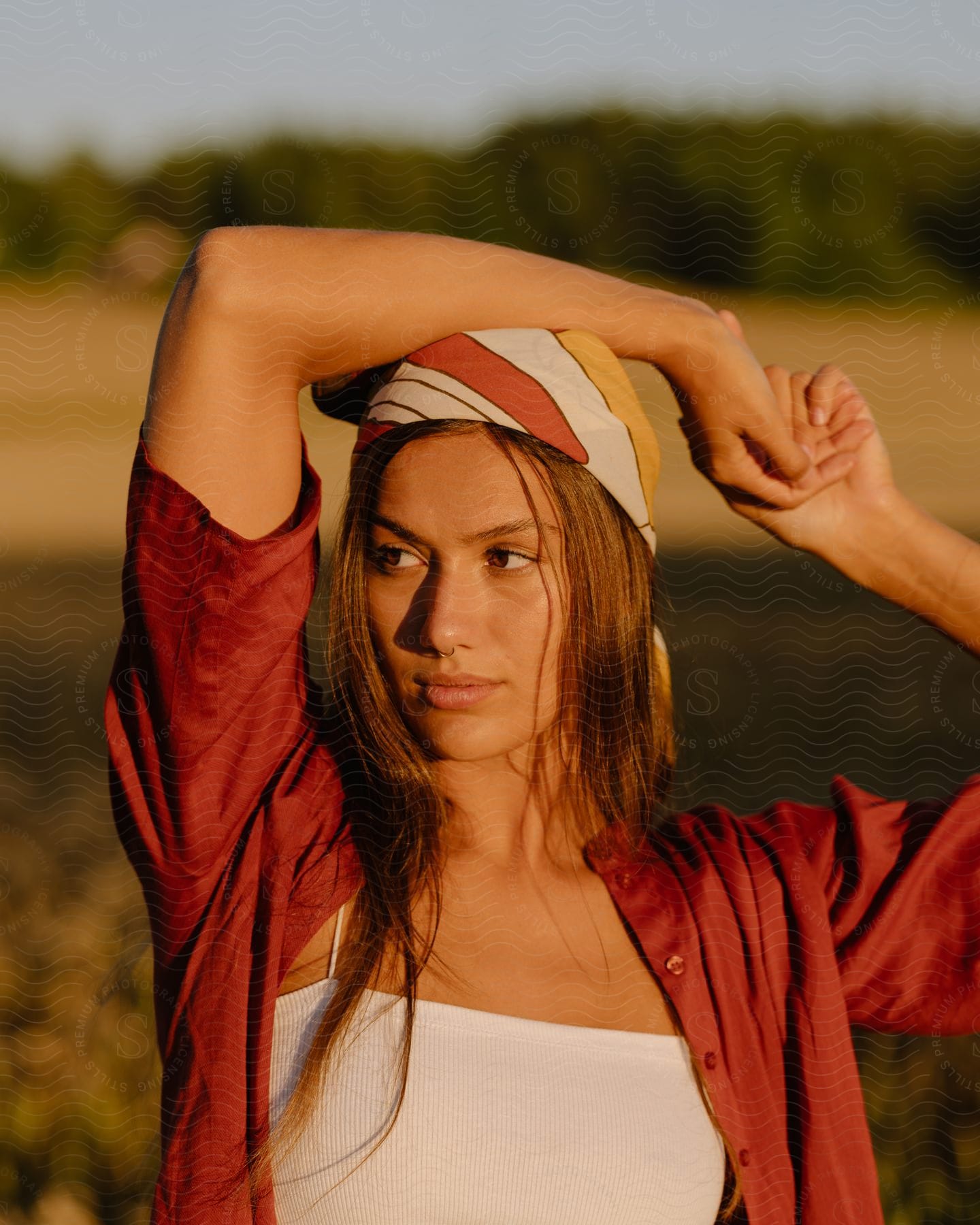 A woman standing outdoors smiling in a natural setting