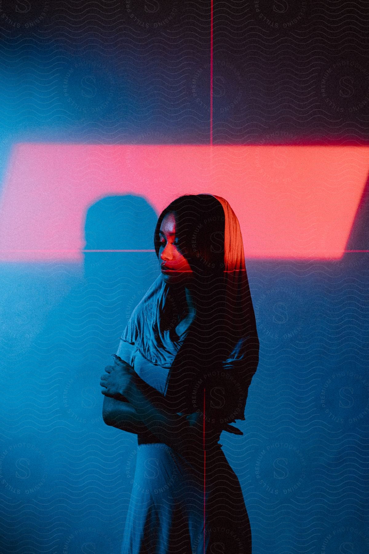 A young woman poses illuminated by red lines