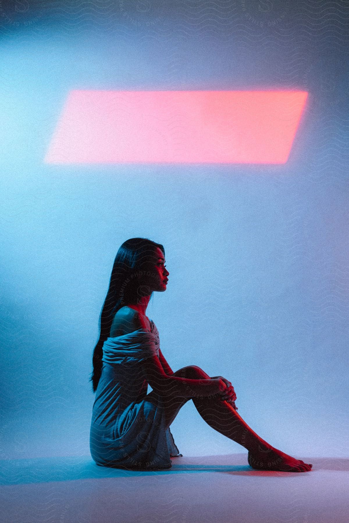 A woman sits on the floor in an empty room