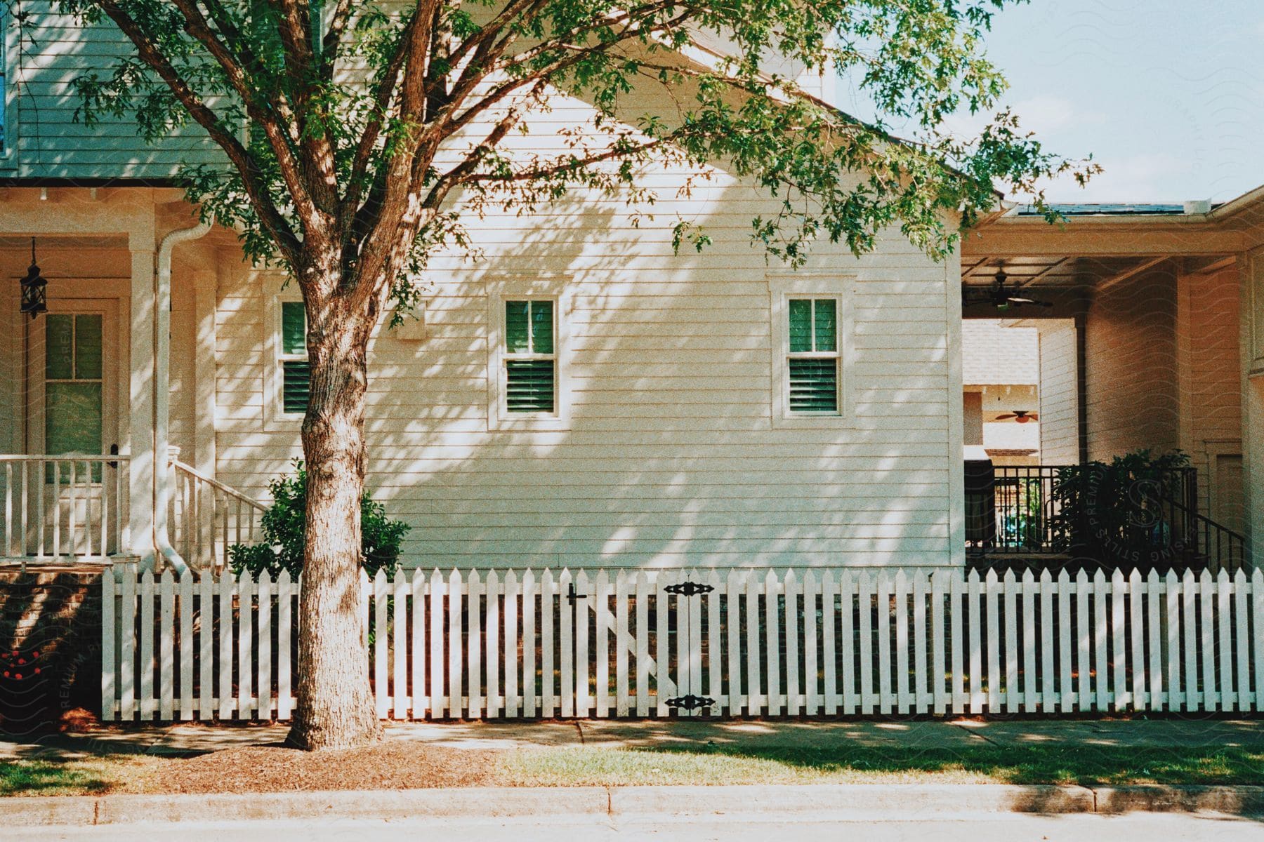 A suburban house with a white picket fence in a residential area