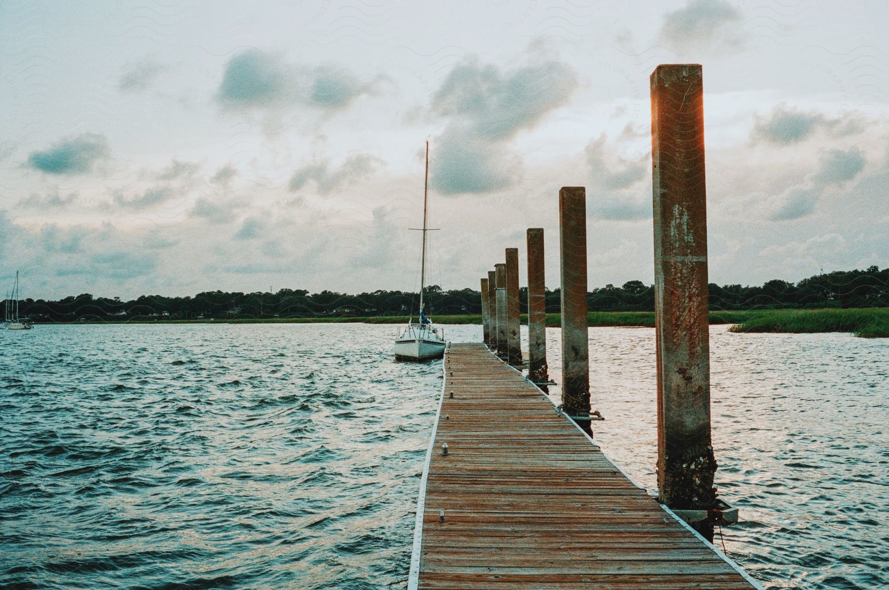 A boat is parked next to a long pier in an outdoor setting