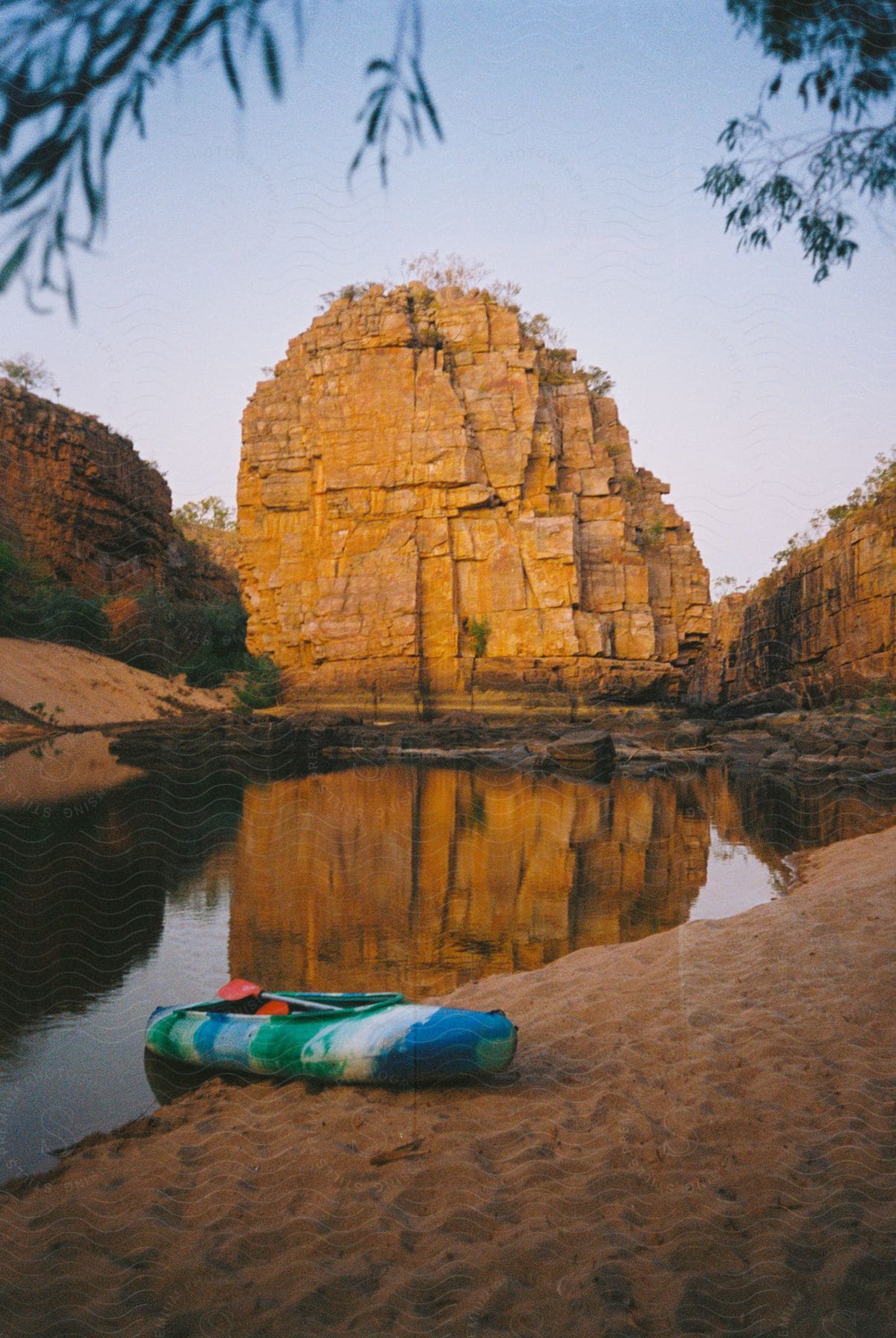 A kayak is on the bank of a river in a canyon