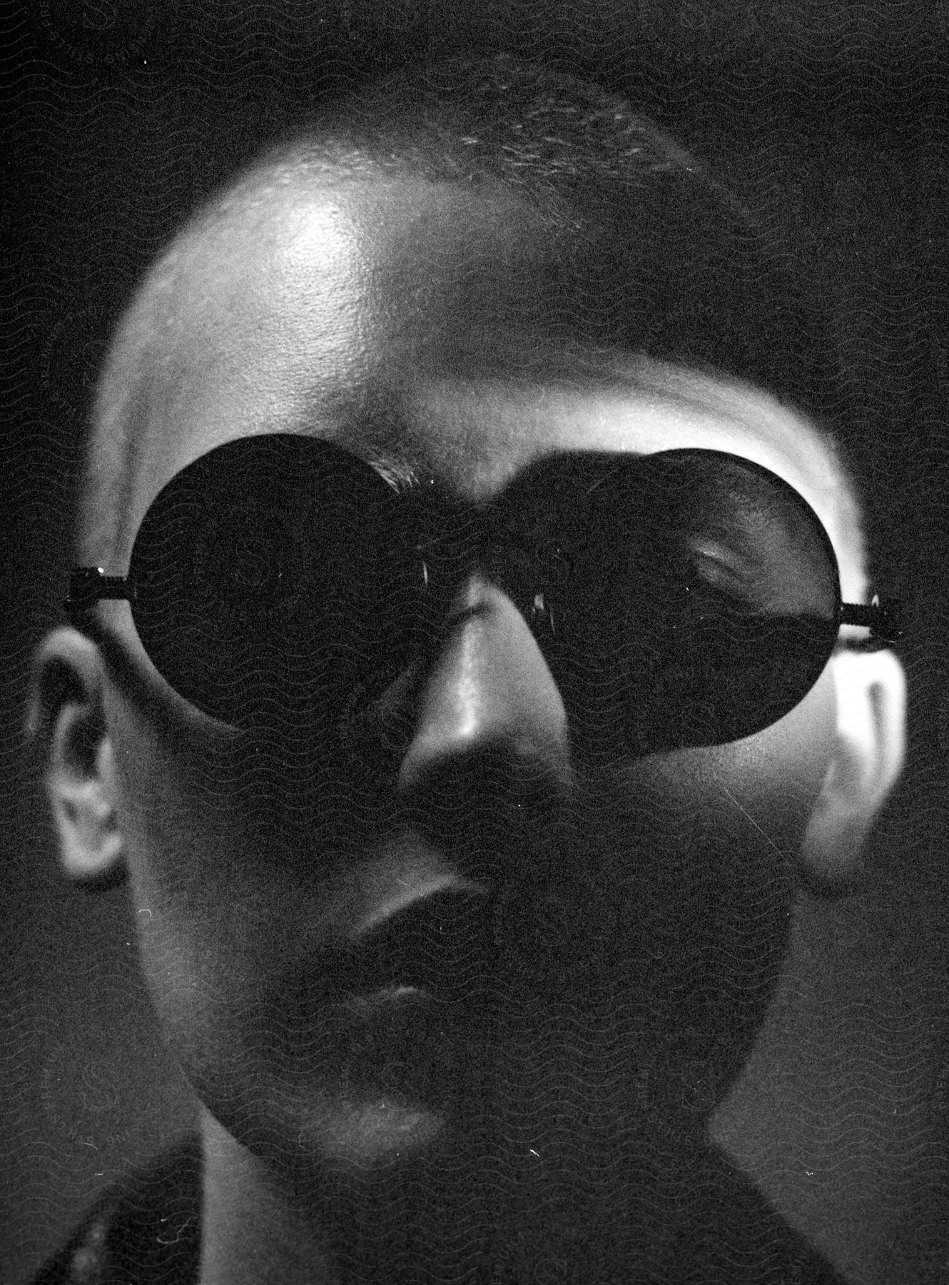 Close-up of a person's face wearing sunglasses.