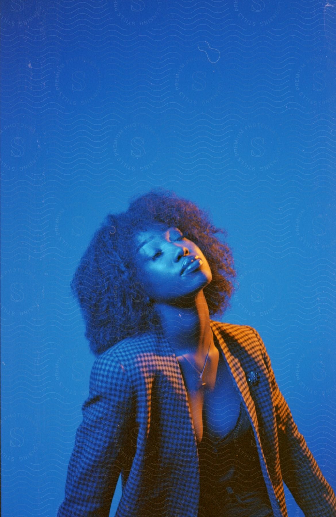 Black woman with afro hair on a blue background with subtle lighting