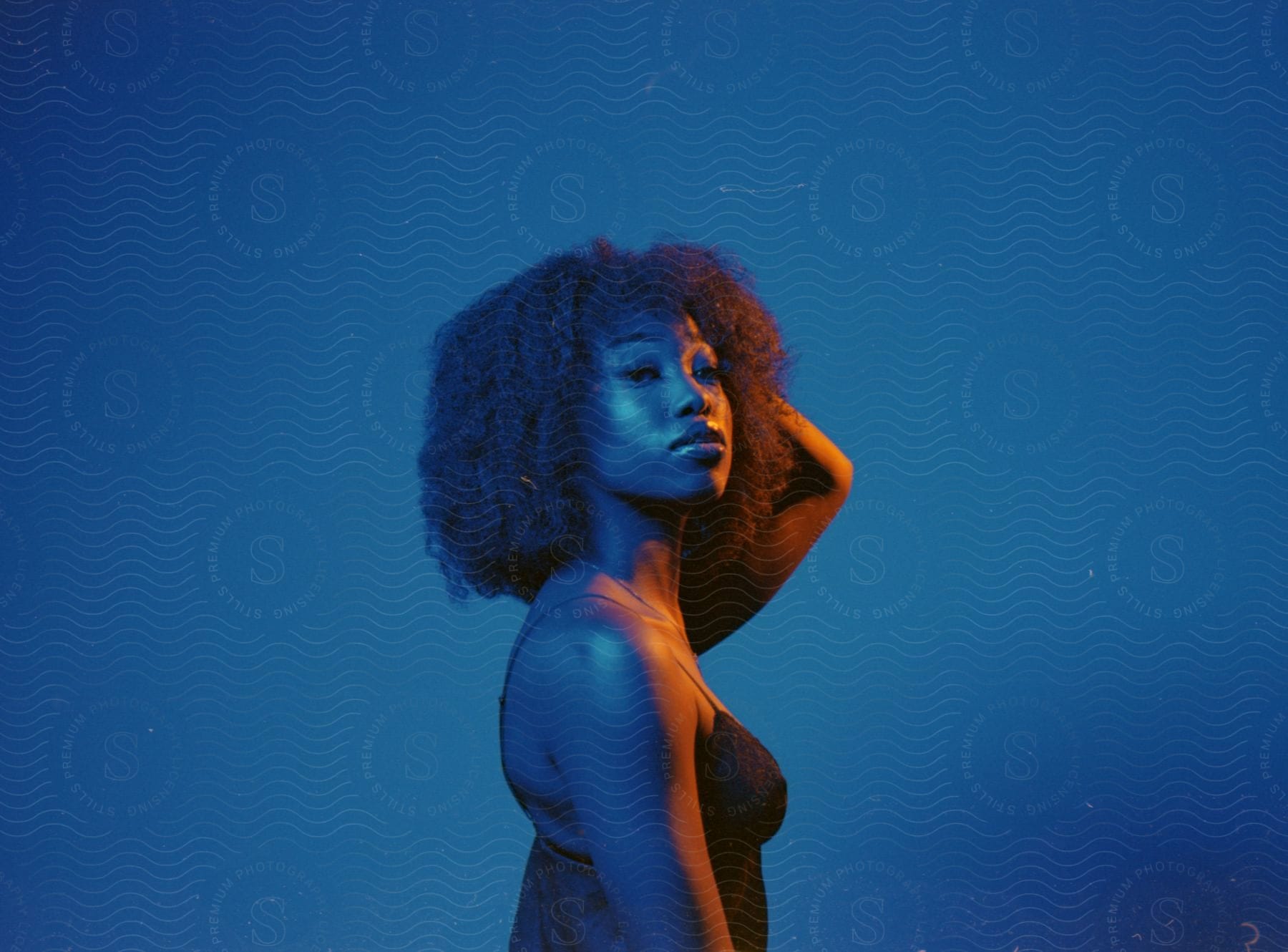 Black woman with an afro under blue and orange contrasting lights