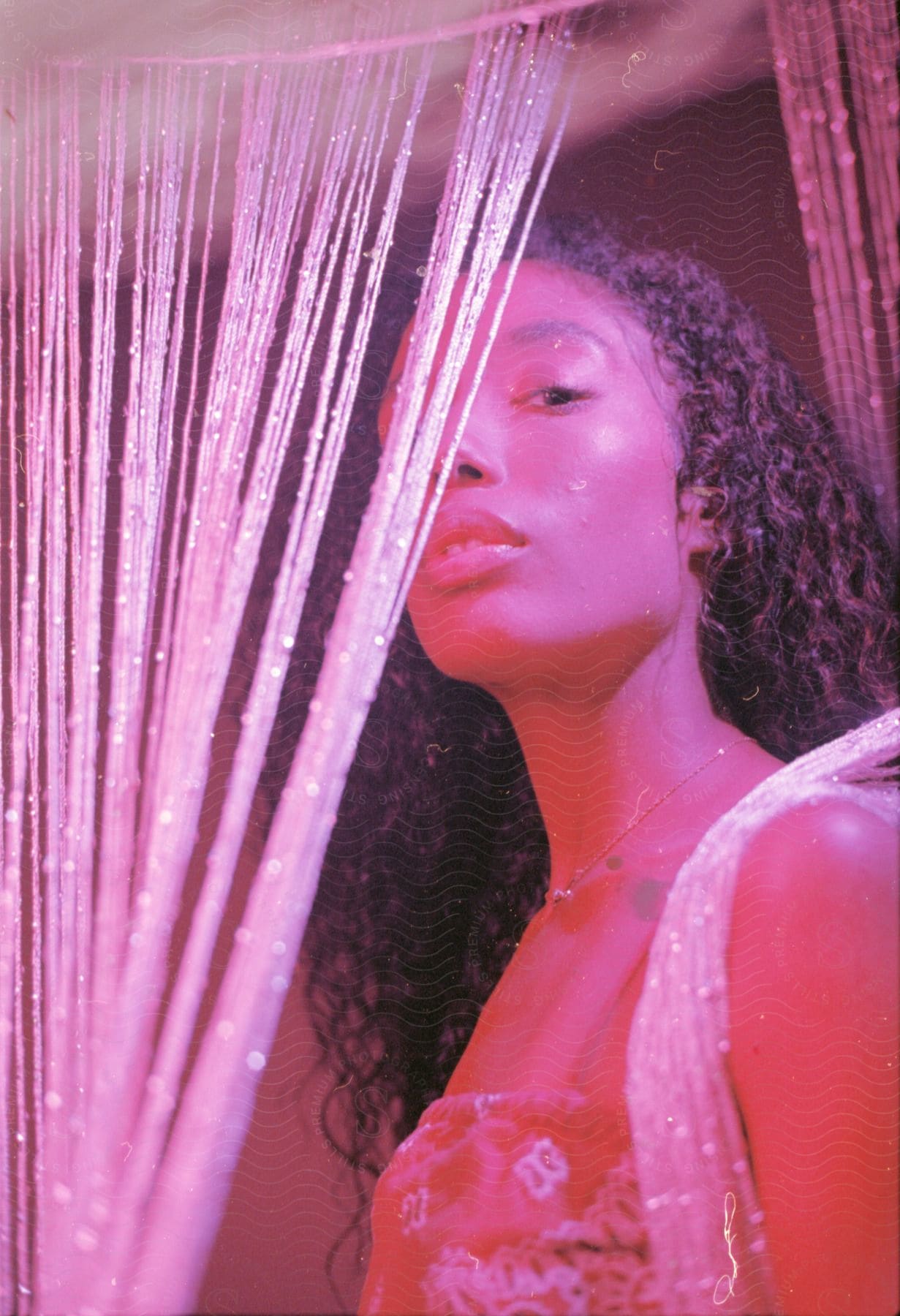 A young woman with curly hair stands in the doorway.