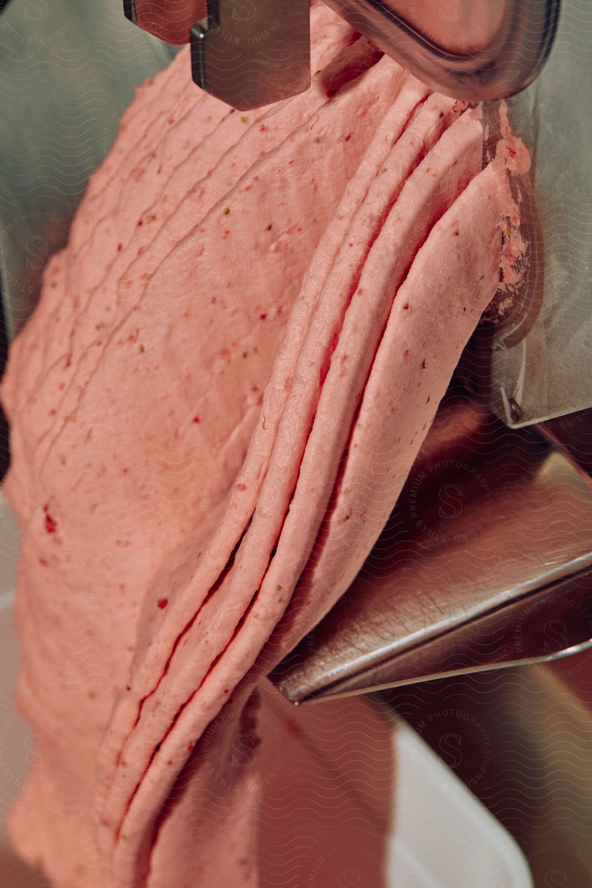 Food paste being dispensed from a food processing machine