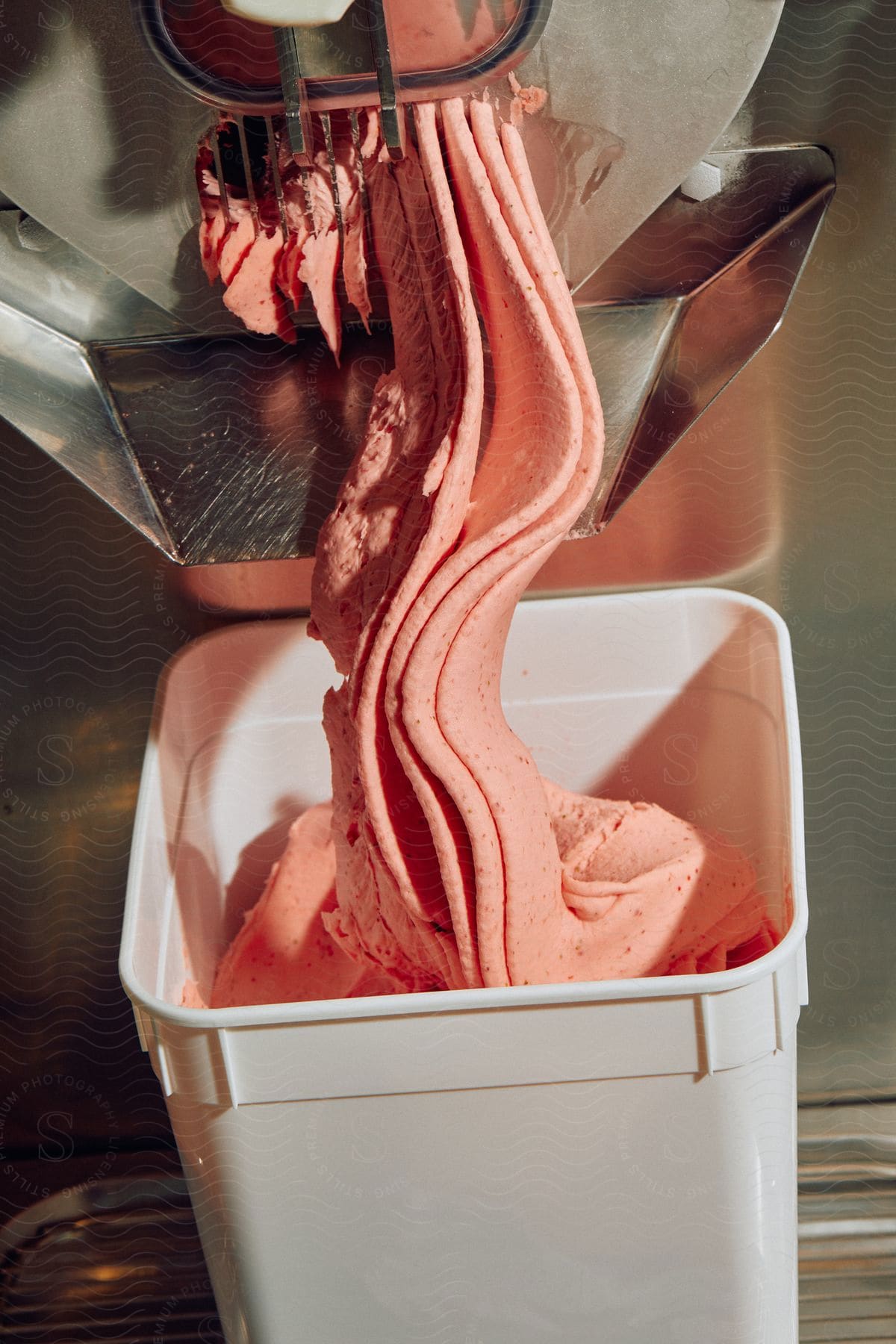 Food processing machine ejecting food paste into a plastic pot