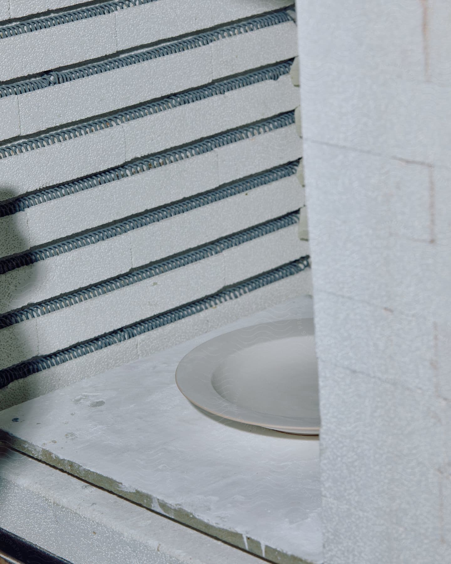 Minimalist room with round plate placed on white floor highlighting plate as visual centerpiece