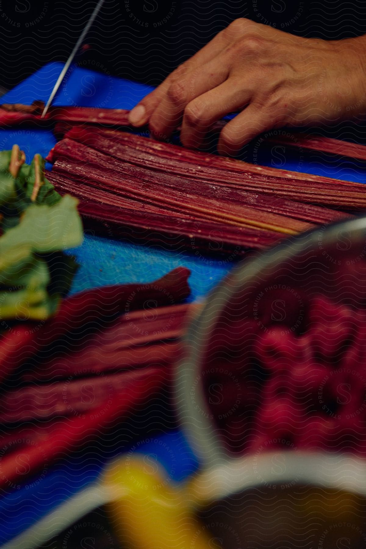 Chef slicing vegetables with a sharp kitchen knife on a chopping board