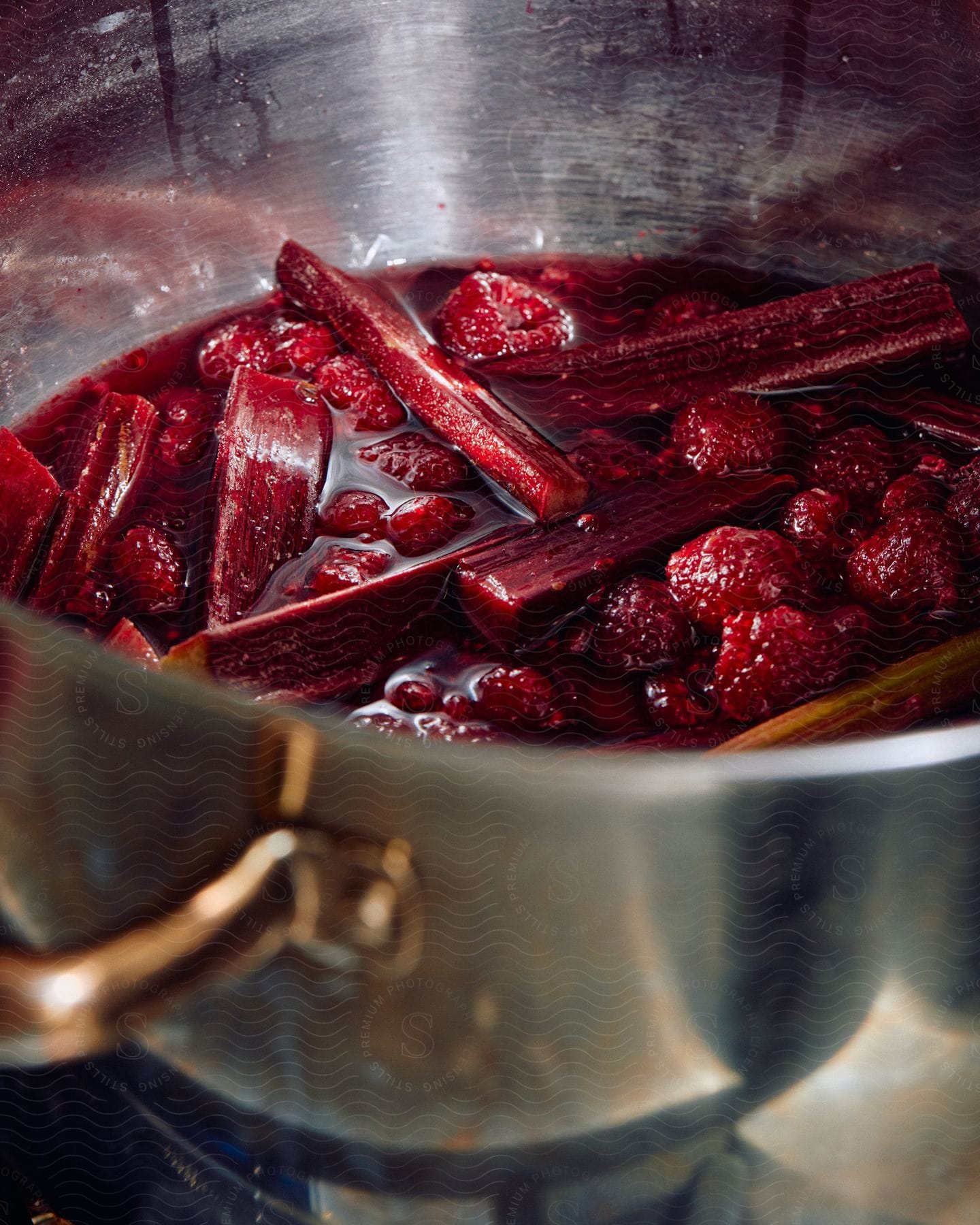 Close up of a sweet red fruit candy or jam cooking on a steel pot