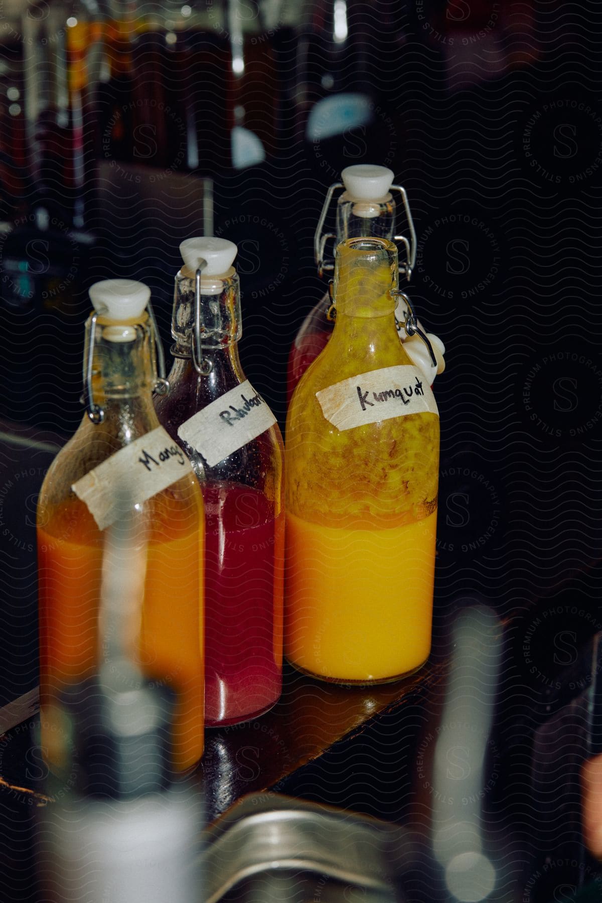 Close up of bottle filled with natural fruit juices on a bar counter