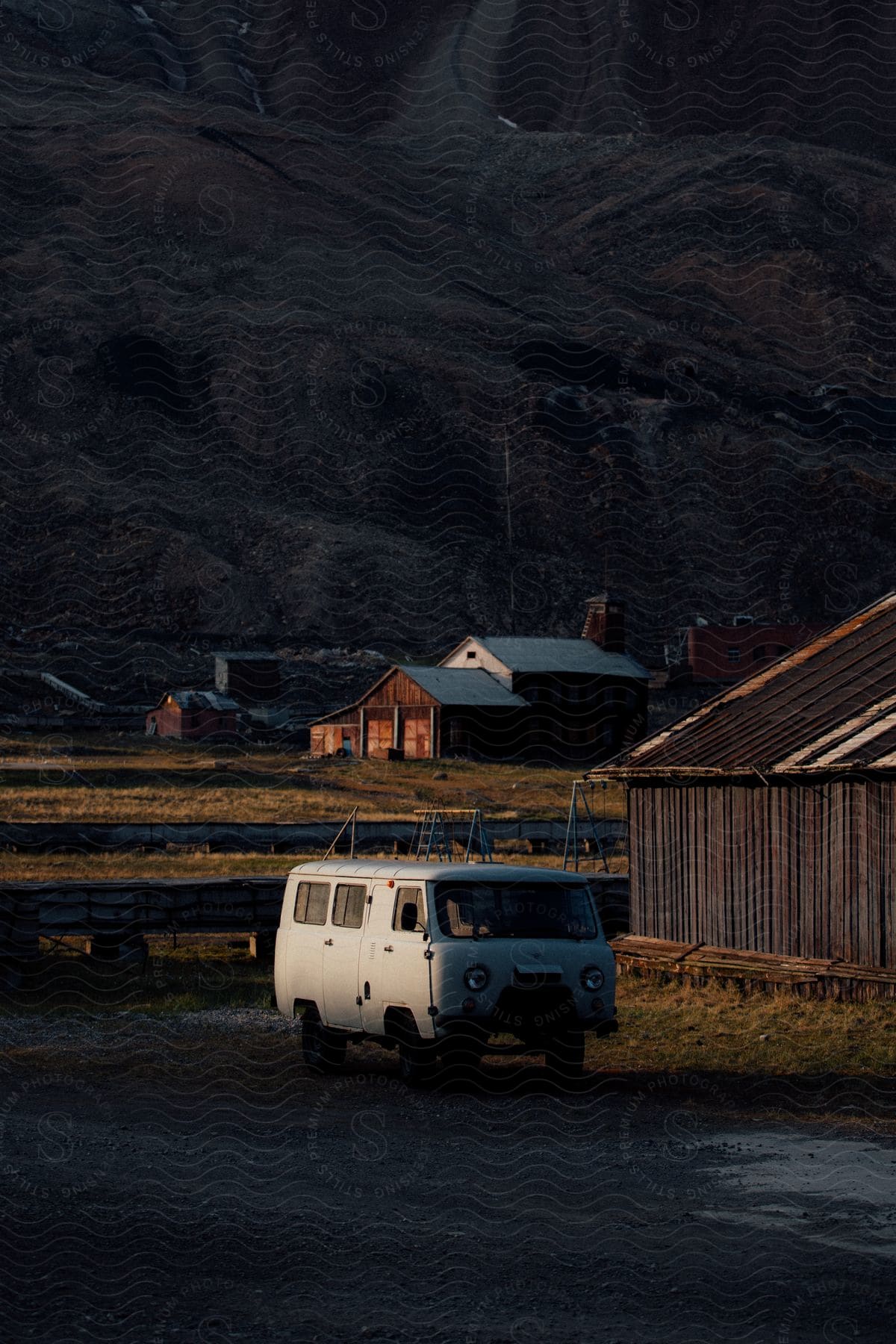 An old van is parked next to a building in a small town