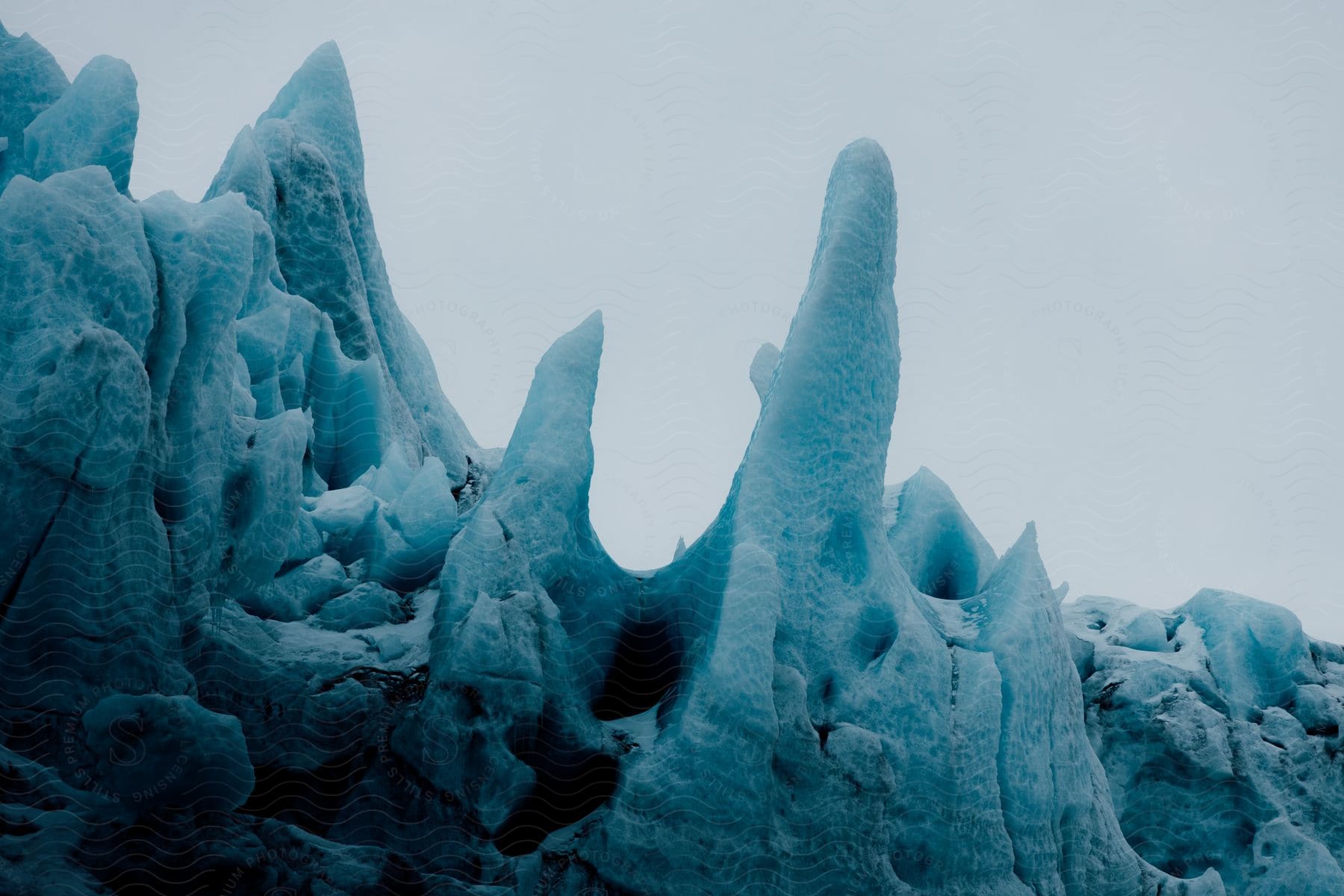 Blue tinted icy rock with an overcast sky