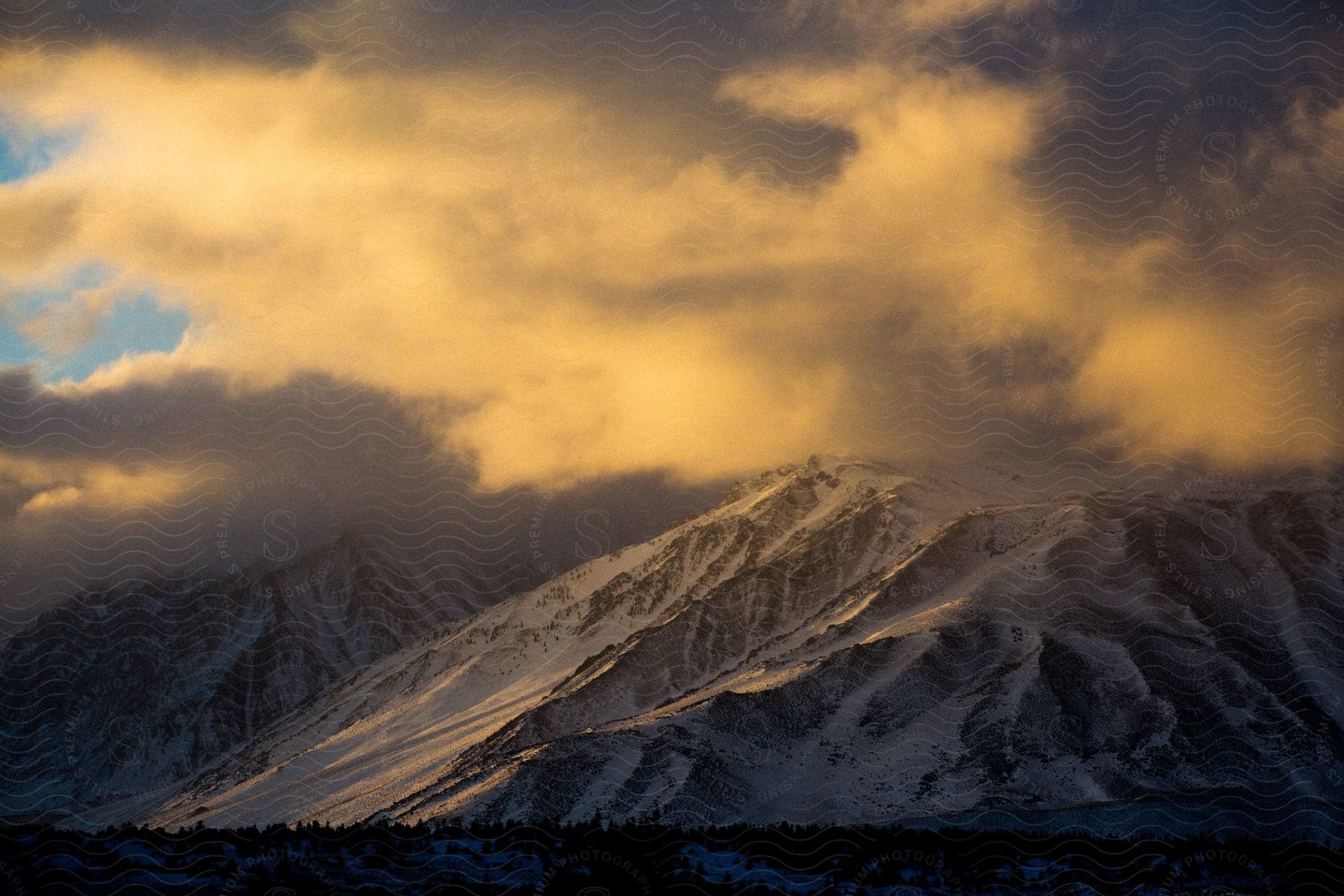Snowcovered valley at sunrise with a snowcapped mountain range in the background peaks hidden by clouds