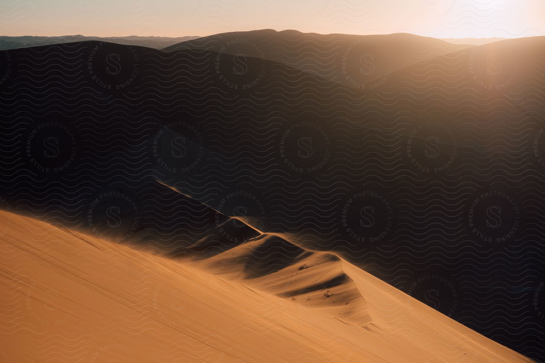 Desert dunes with sunrise on the horizon