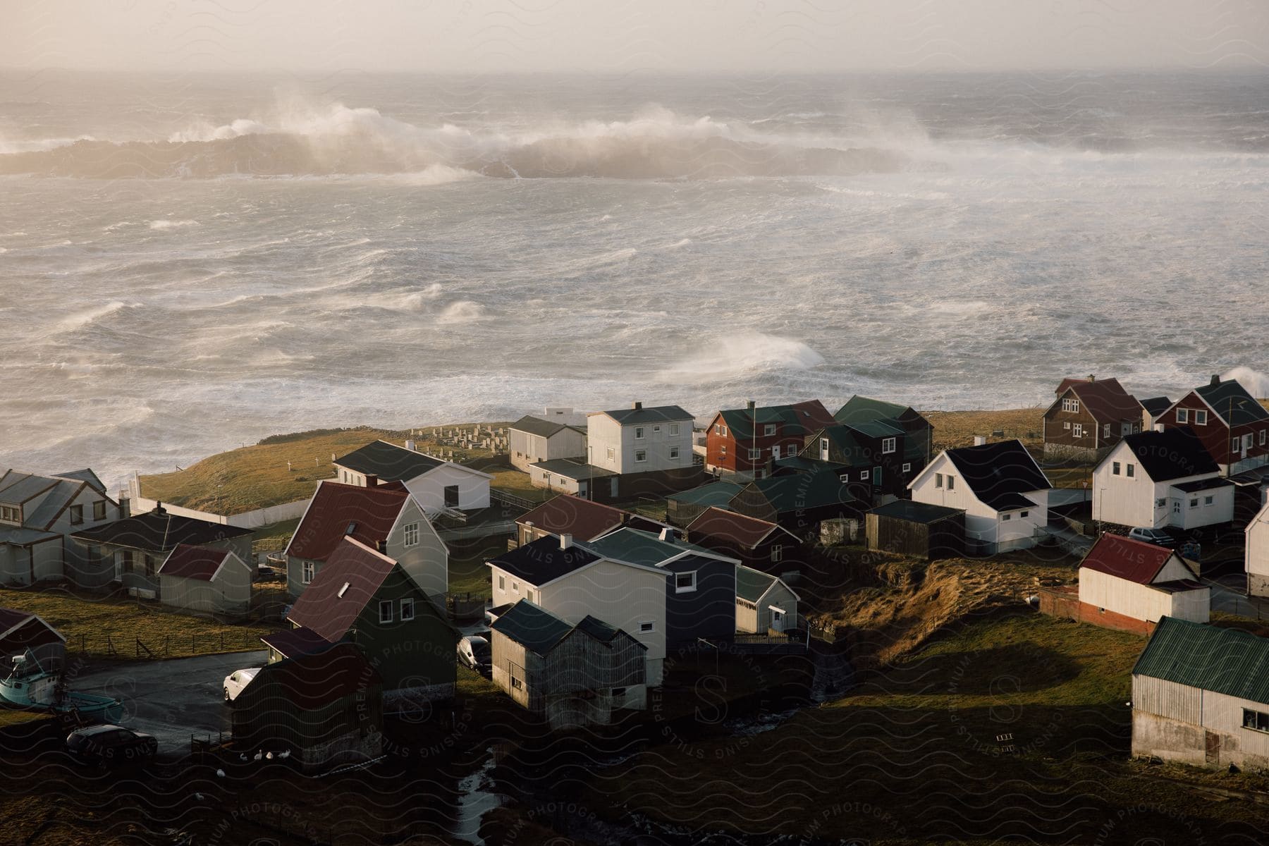 Coastal town overlooking wavy ocean captured from above