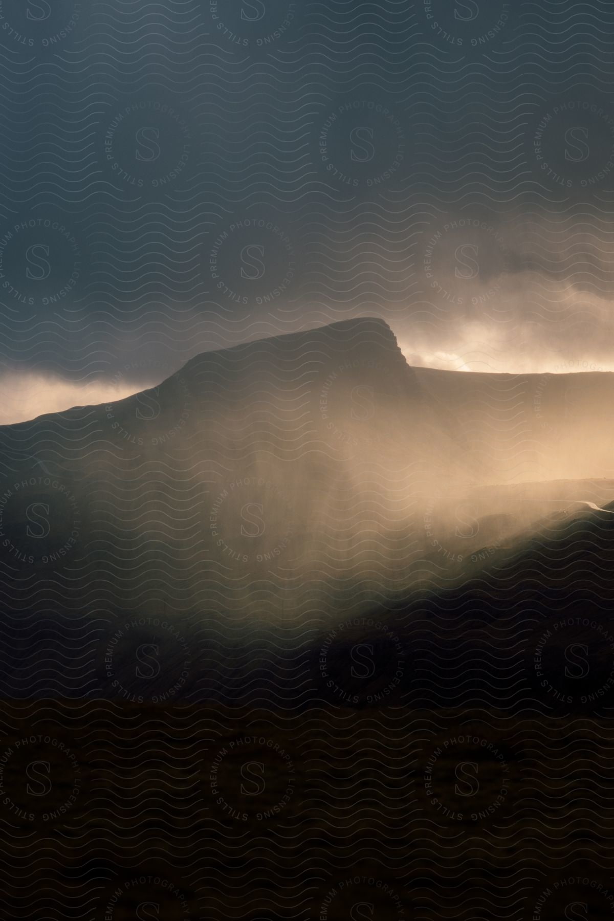 A mountain is visible through a hazy atmosphere at dawn