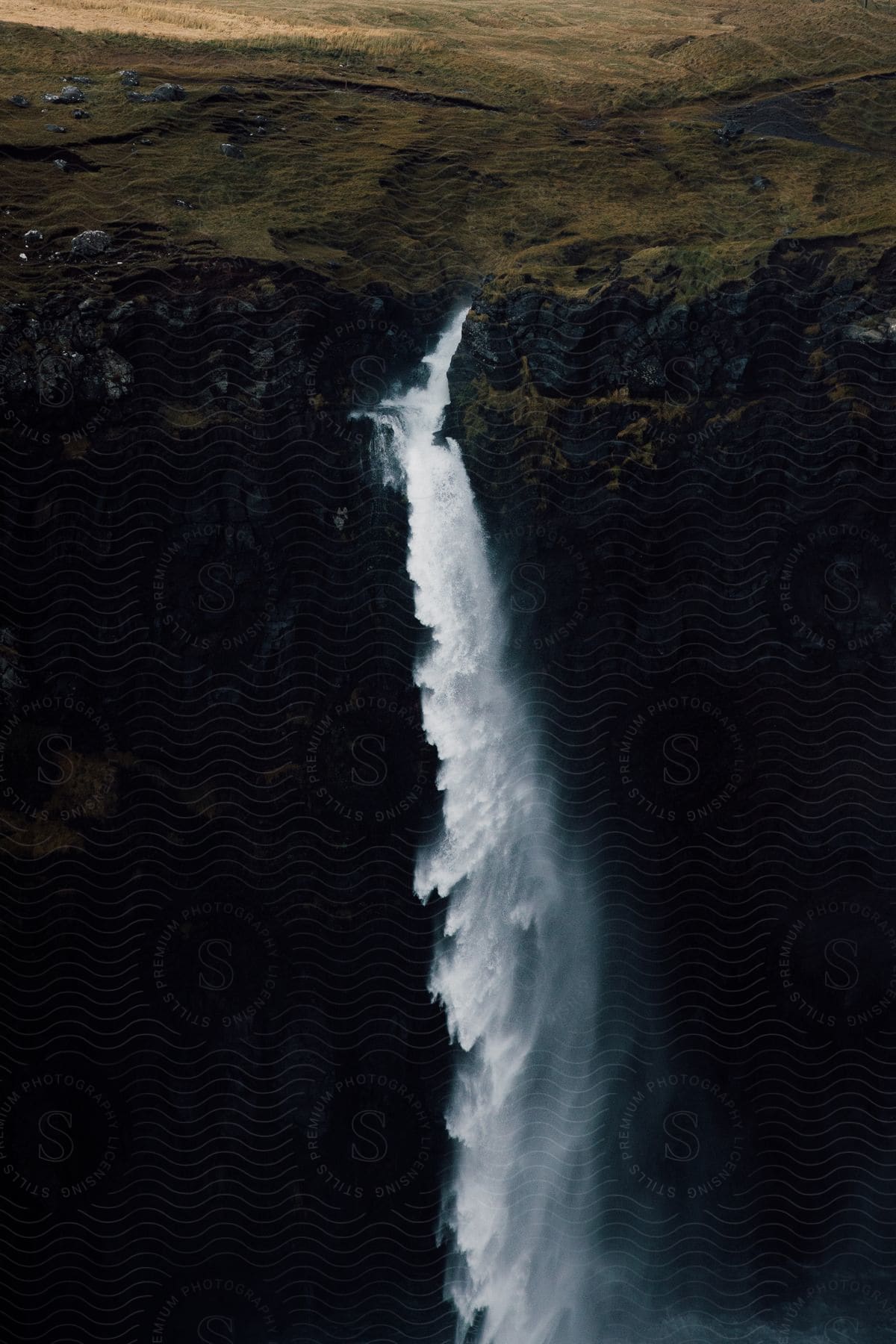 Aerial view of waterfall cascading down mountainside in the faroe islands