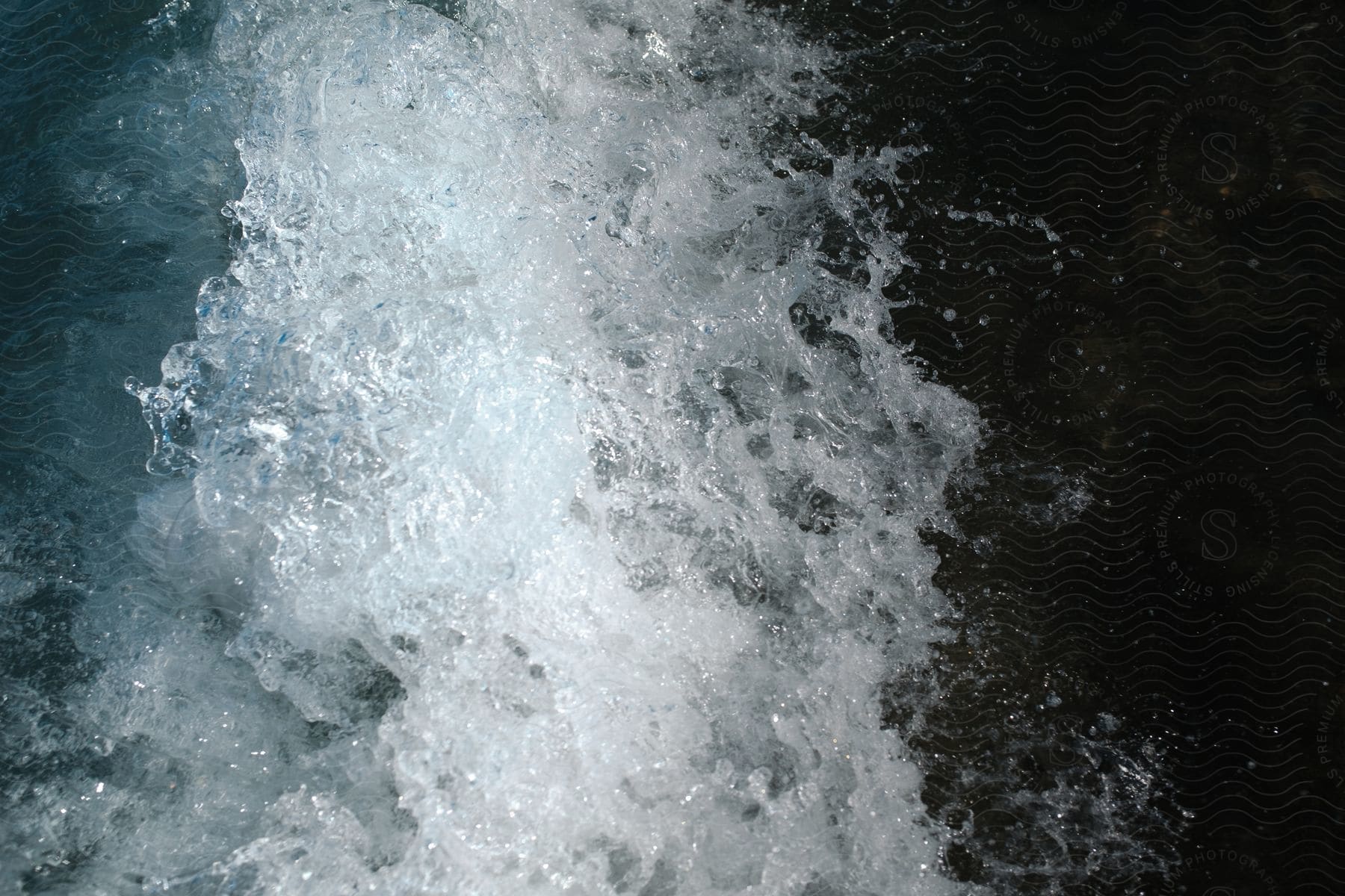 A close up of a violently crashing wave in the ocean