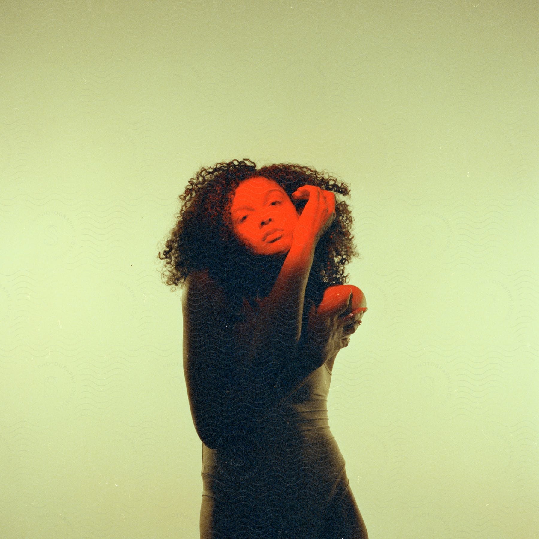 A young woman with curly hair and a green dress.