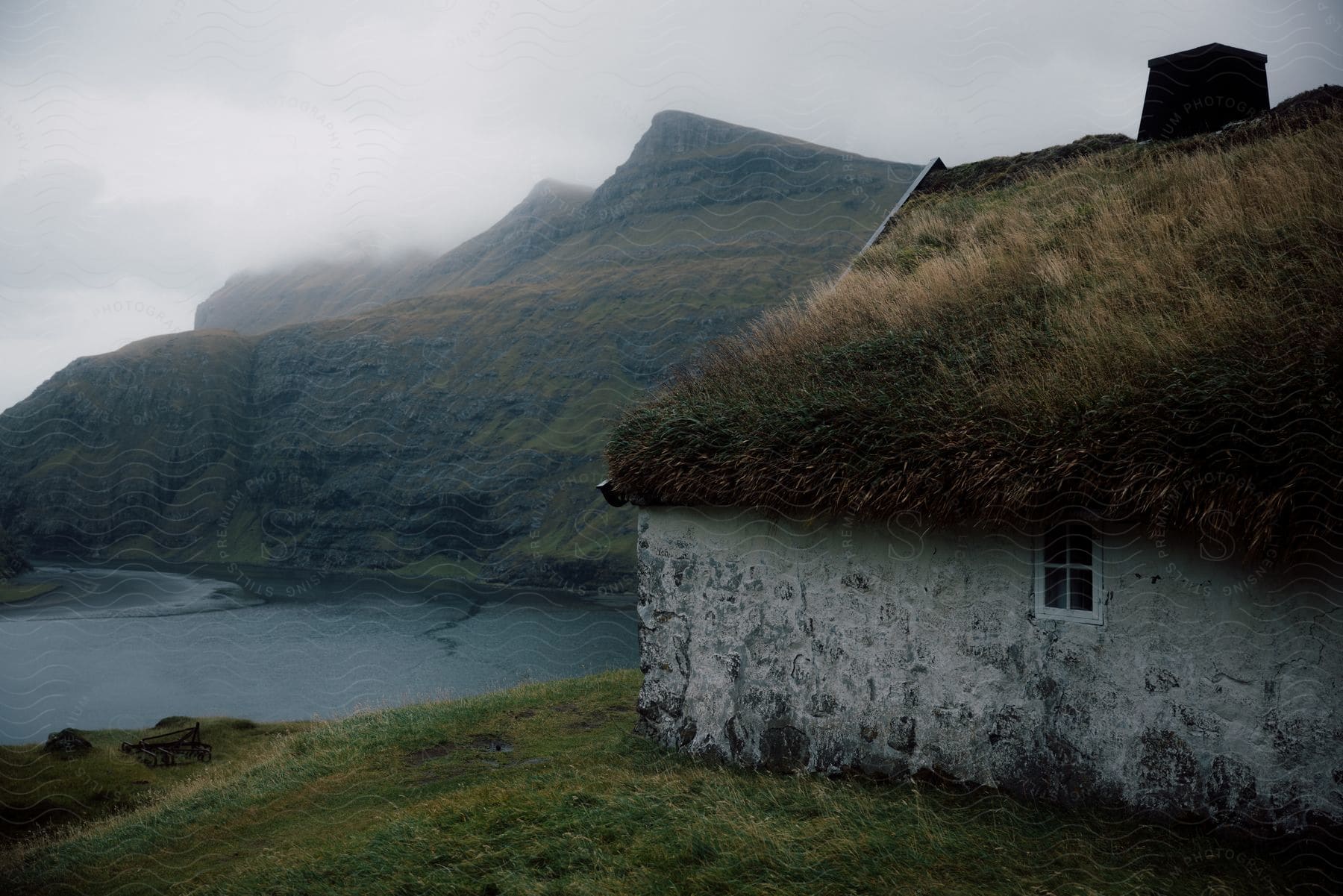 A coastal island house with sea rocky mountains and undergrowth