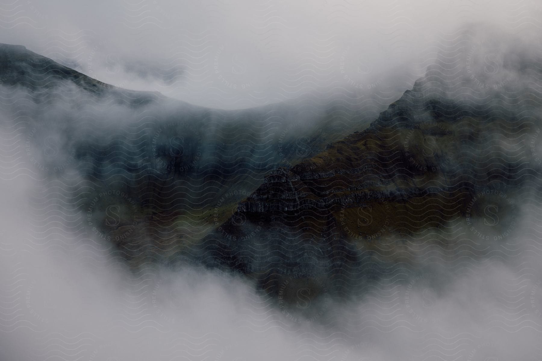 Mountains covered in mist during the day in an outdoor setting