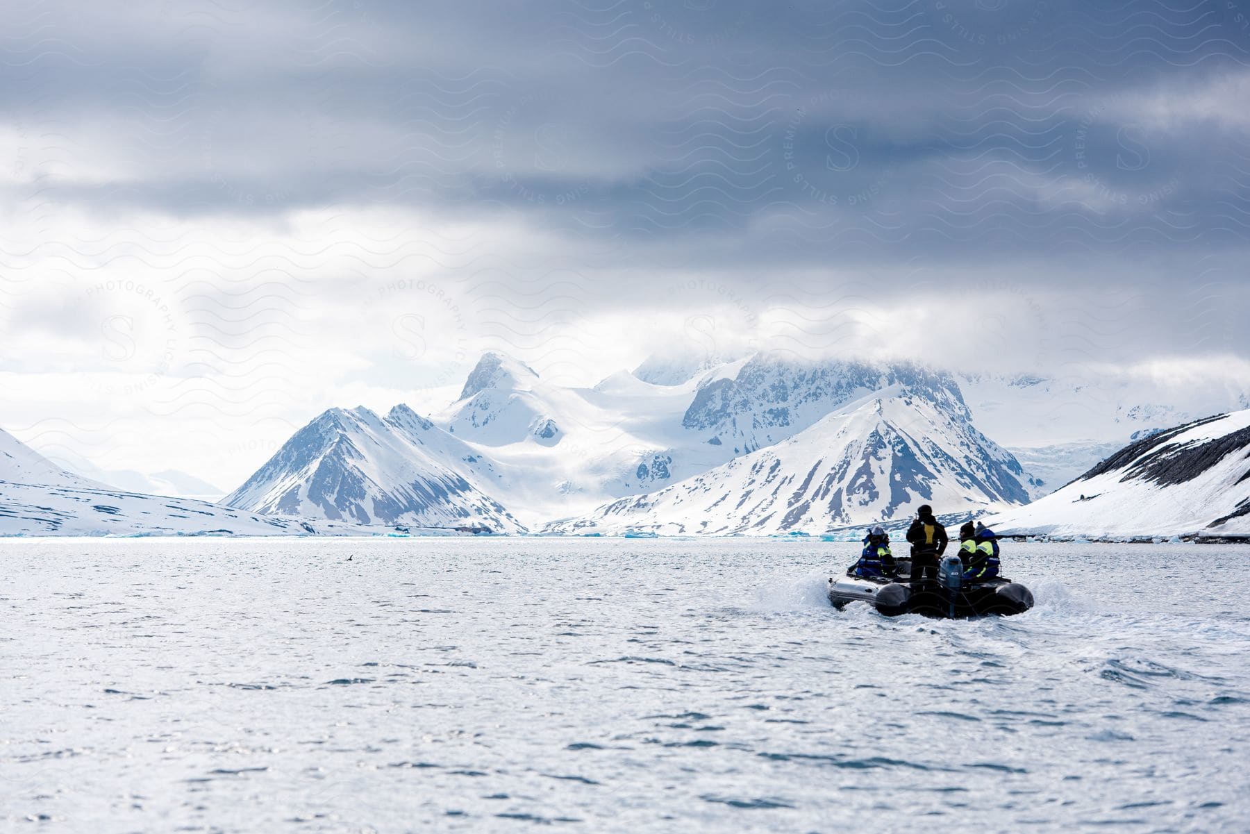 People sailing in a small boat in a landscape with mountains and glaciers