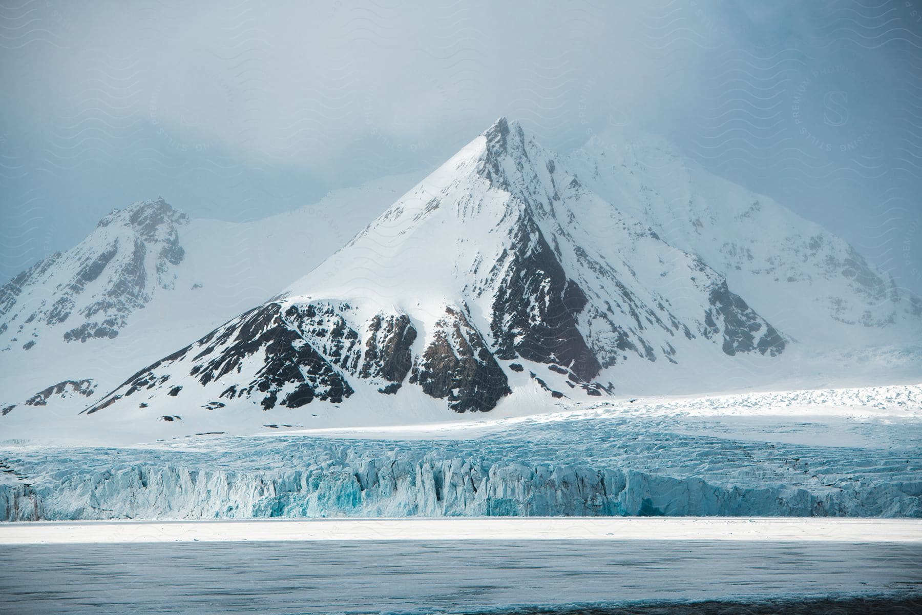 Landscape of snowcovered mountain range surrounded by ice