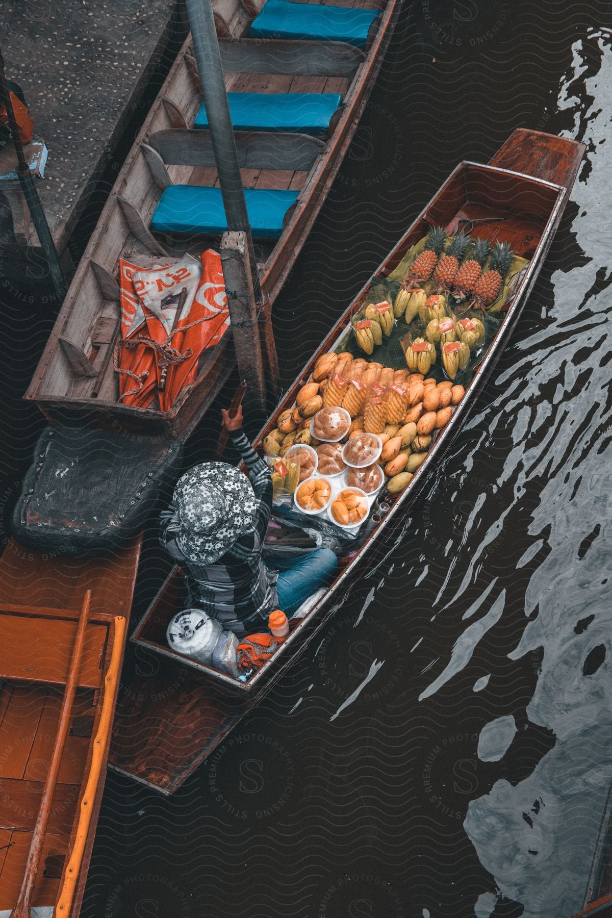 A woman arrives at the shore with a boat full of tropical fruit